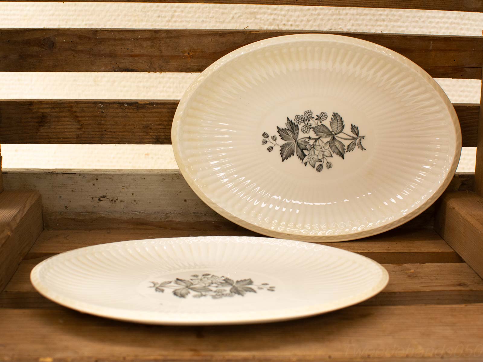 Elegant vintage oval serving plates with floral designs on rustic wood backdrop. Perfect for classic decor.