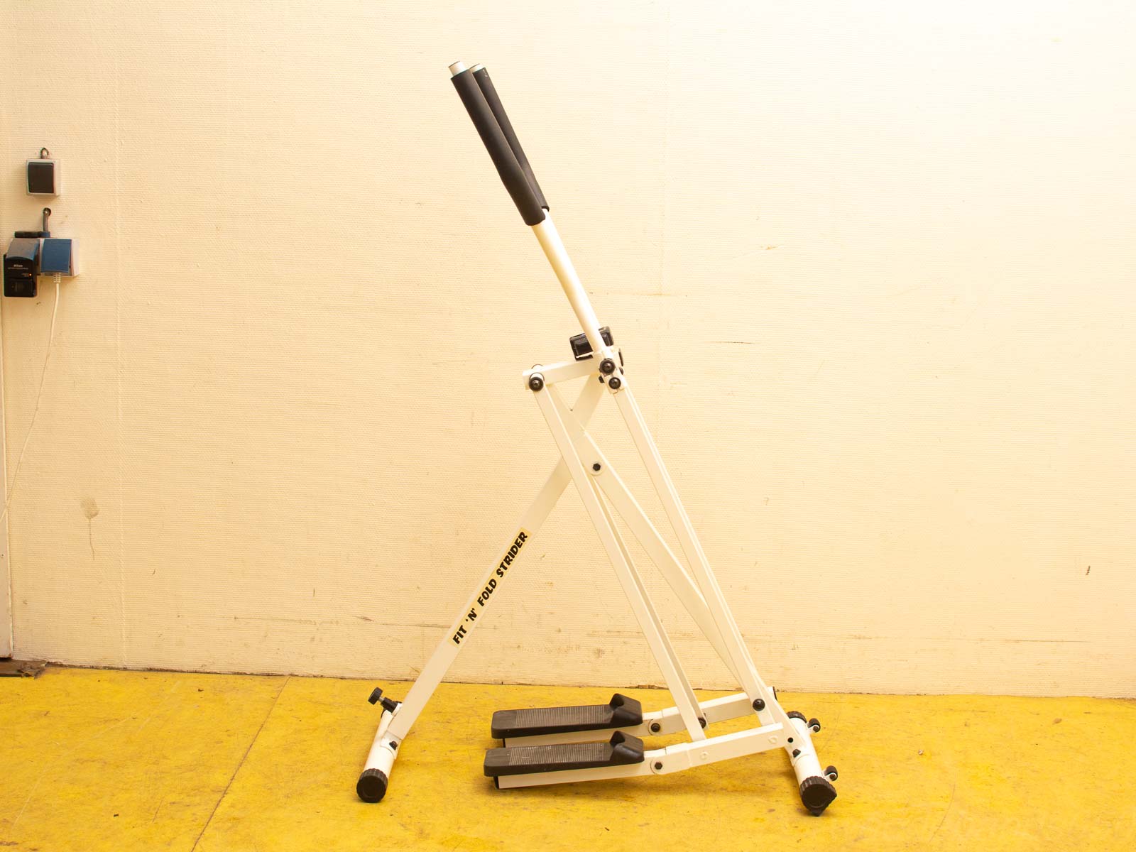 Foldable white stepper with adjustable pedals for effective home workouts in small spaces.