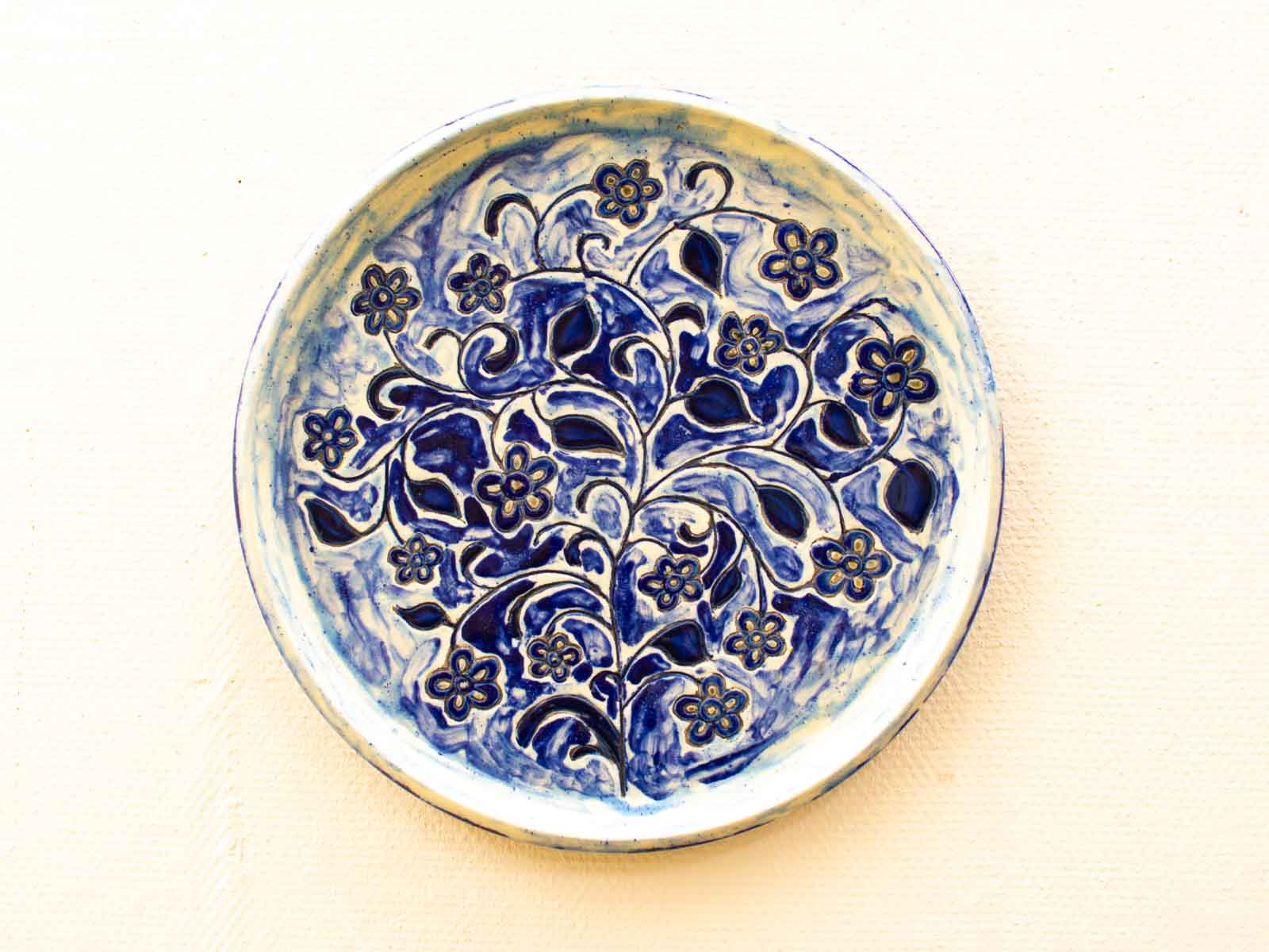 Elegant ceramic plate with vibrant blue floral design, perfect for artistic table settings.