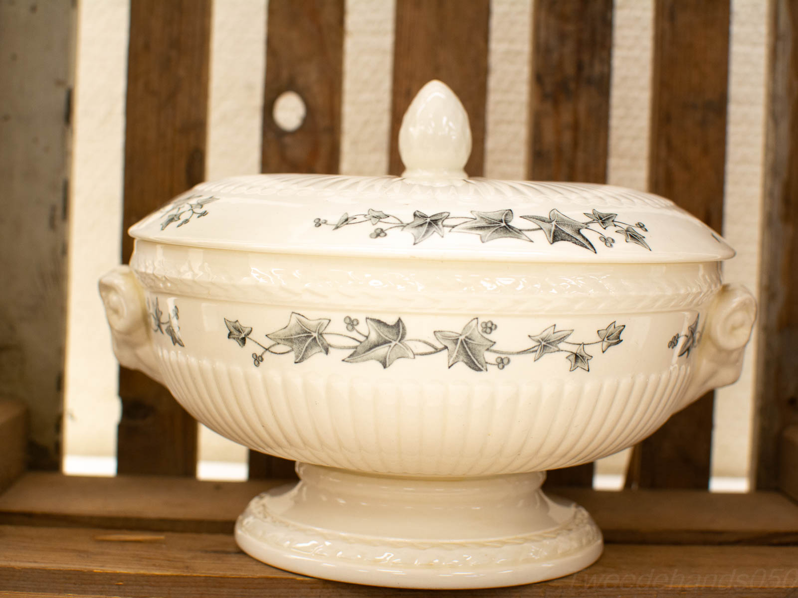 Elegant porcelain serving dish with ivy motifs and whimsical face handles, perfect for any table.