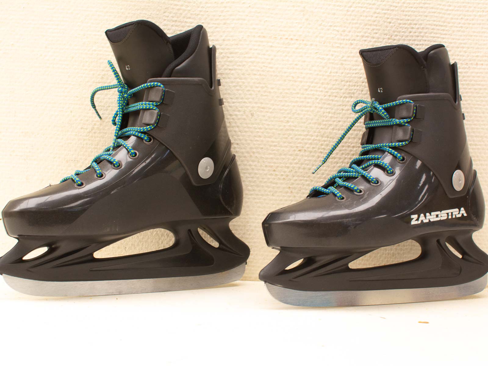 Zandstra ice skates in sleek black with vibrant turquoise laces and high-performance silver blades.