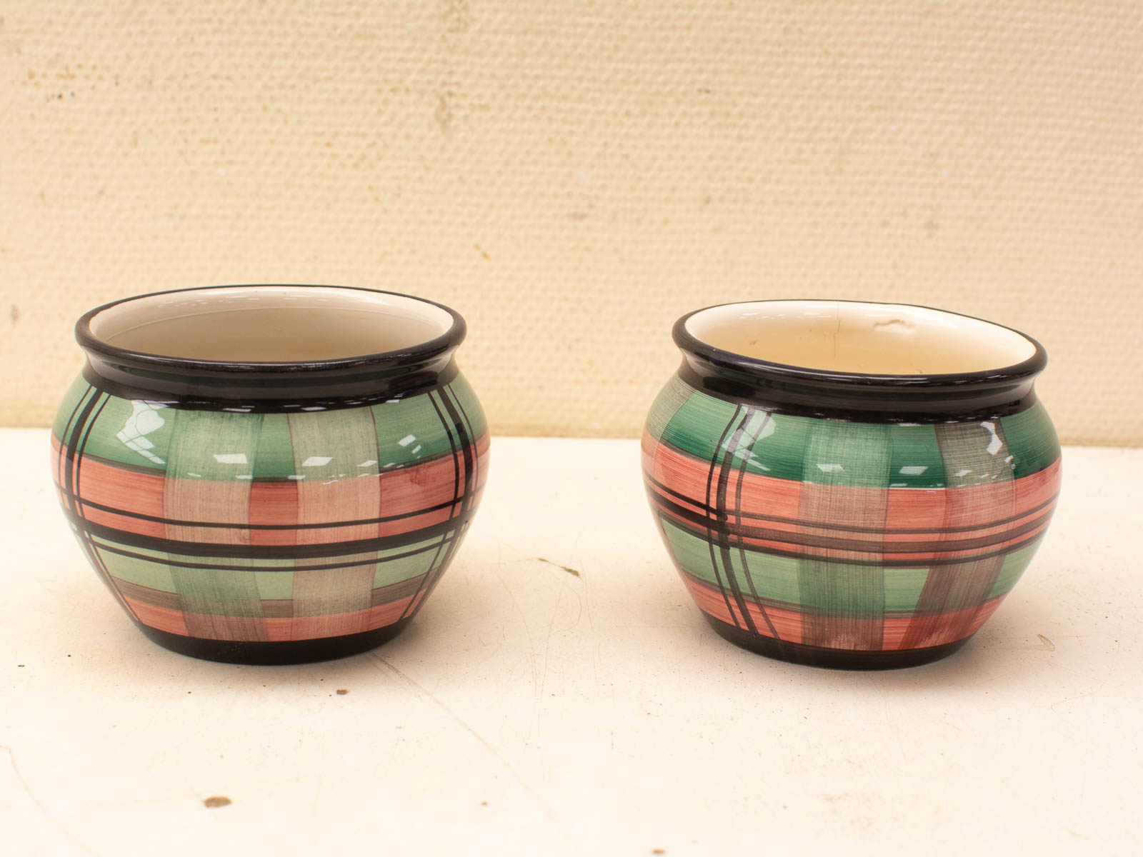 Vibrant plaid ceramic pots in green and pink enhance any decor with artisan charm.