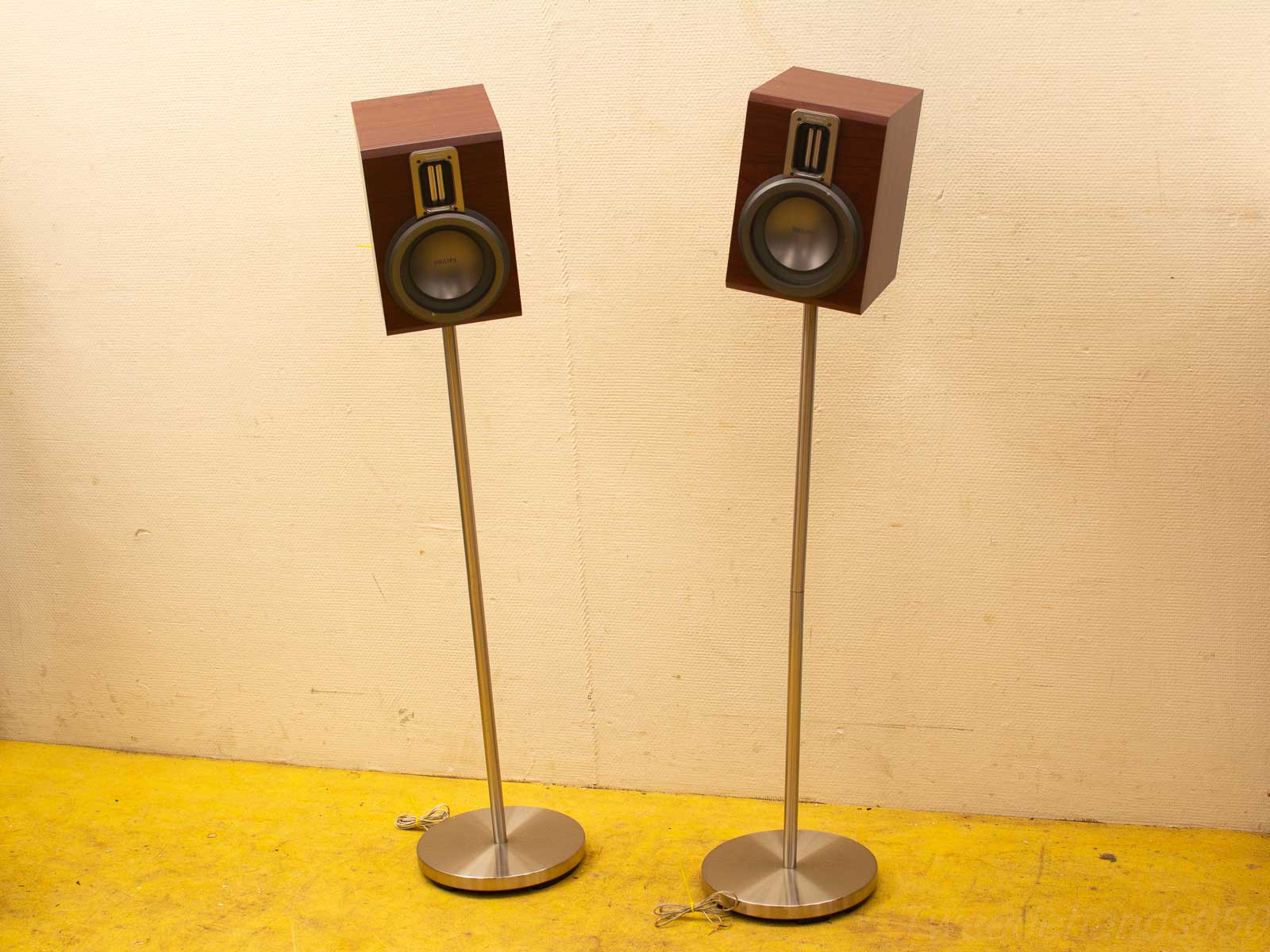 Sleek wooden speakers on metal stands, enhancing audio experience and modern interior style.