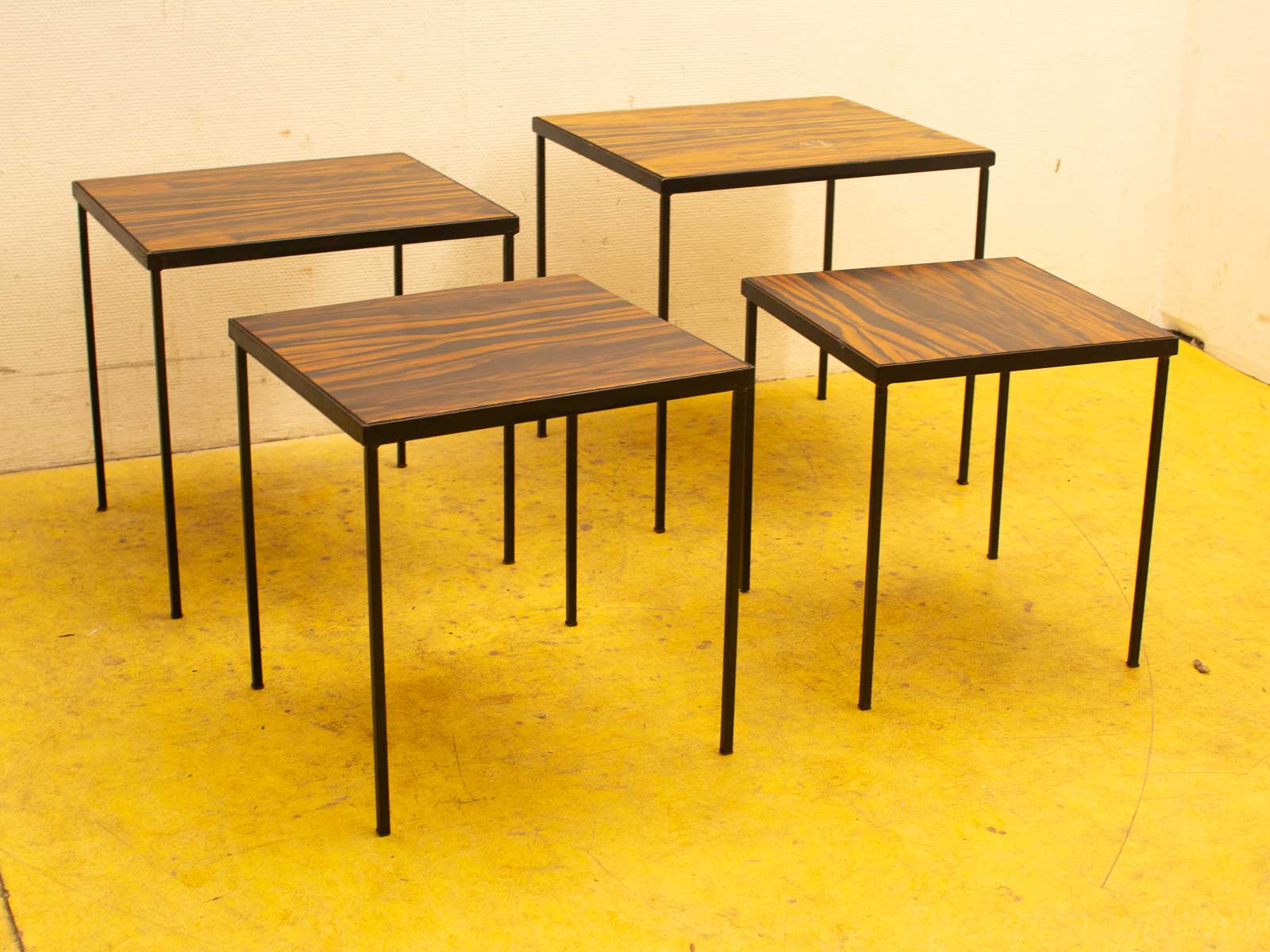 Set of four modern square tables with elegant wood tops and sleek black metal legs.