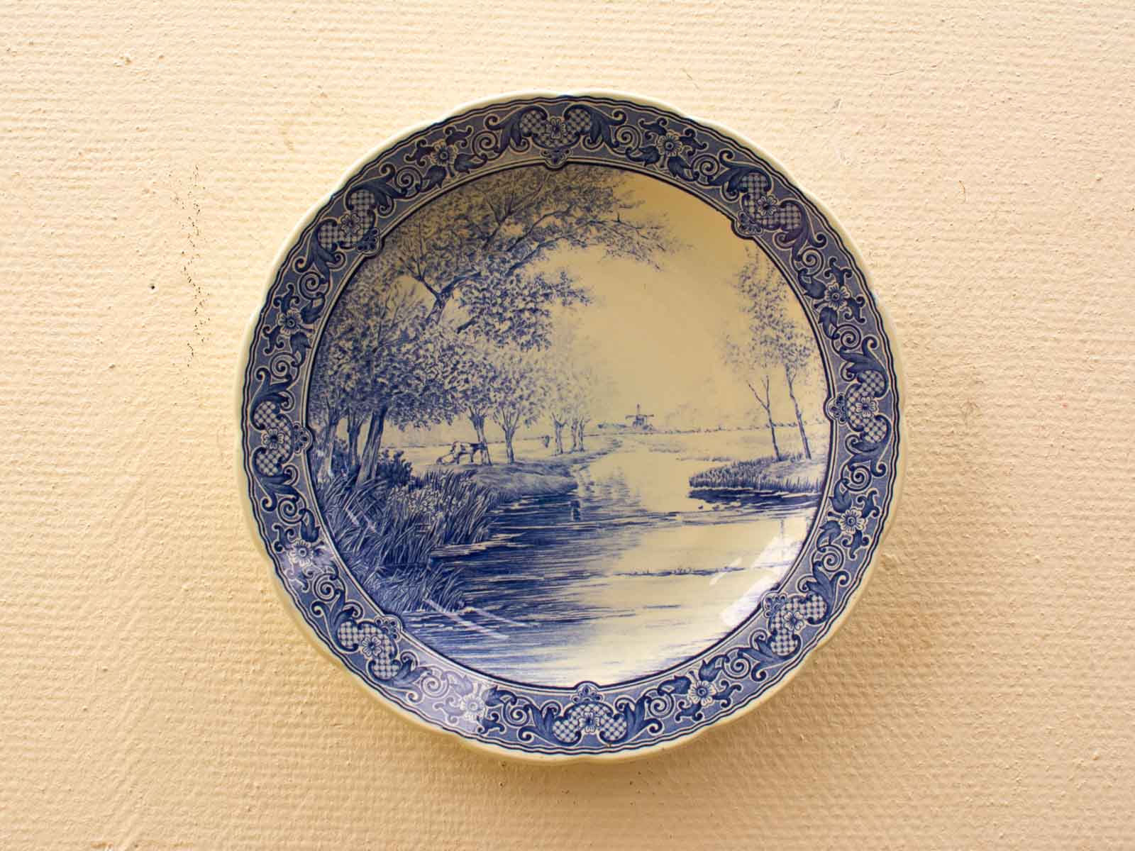 Elegant blue and white decorative plate showcasing a serene landscape with a tranquil river.