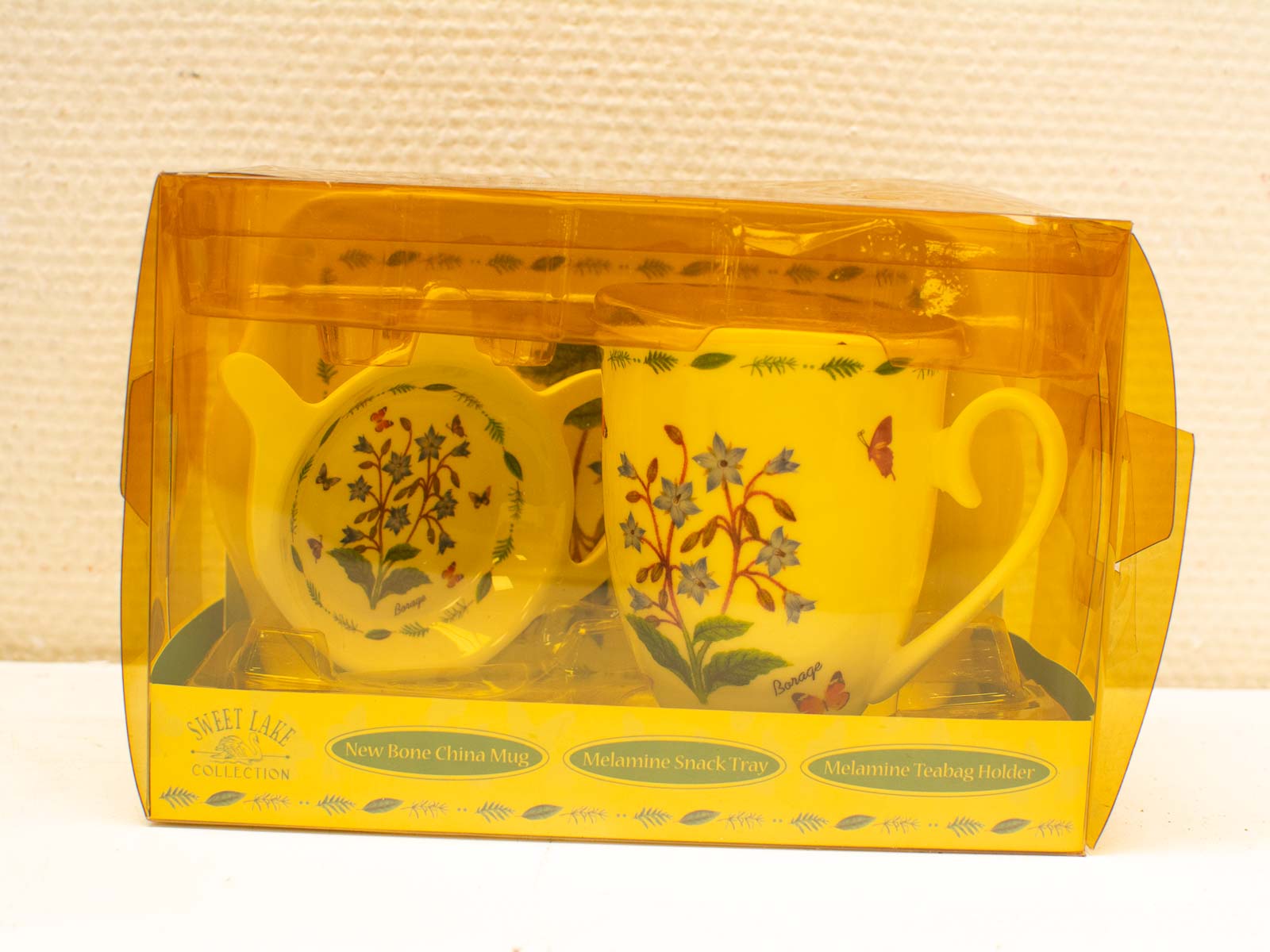 Charming yellow tea set with floral mug, snack tray, and teabag holder, perfect for gifting.