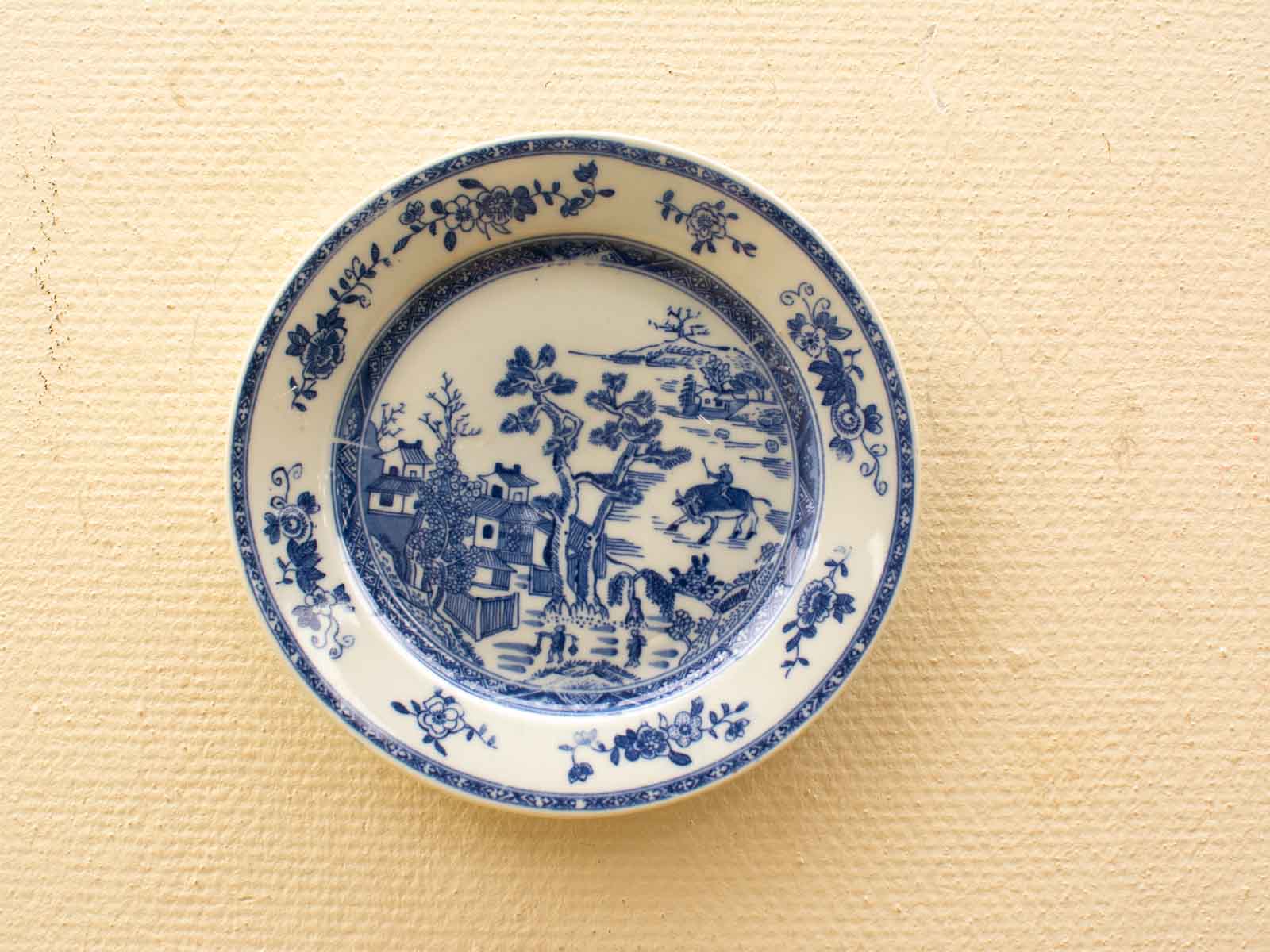 Vintage blue and white ceramic plate featuring intricate landscape design, perfect for collectors.