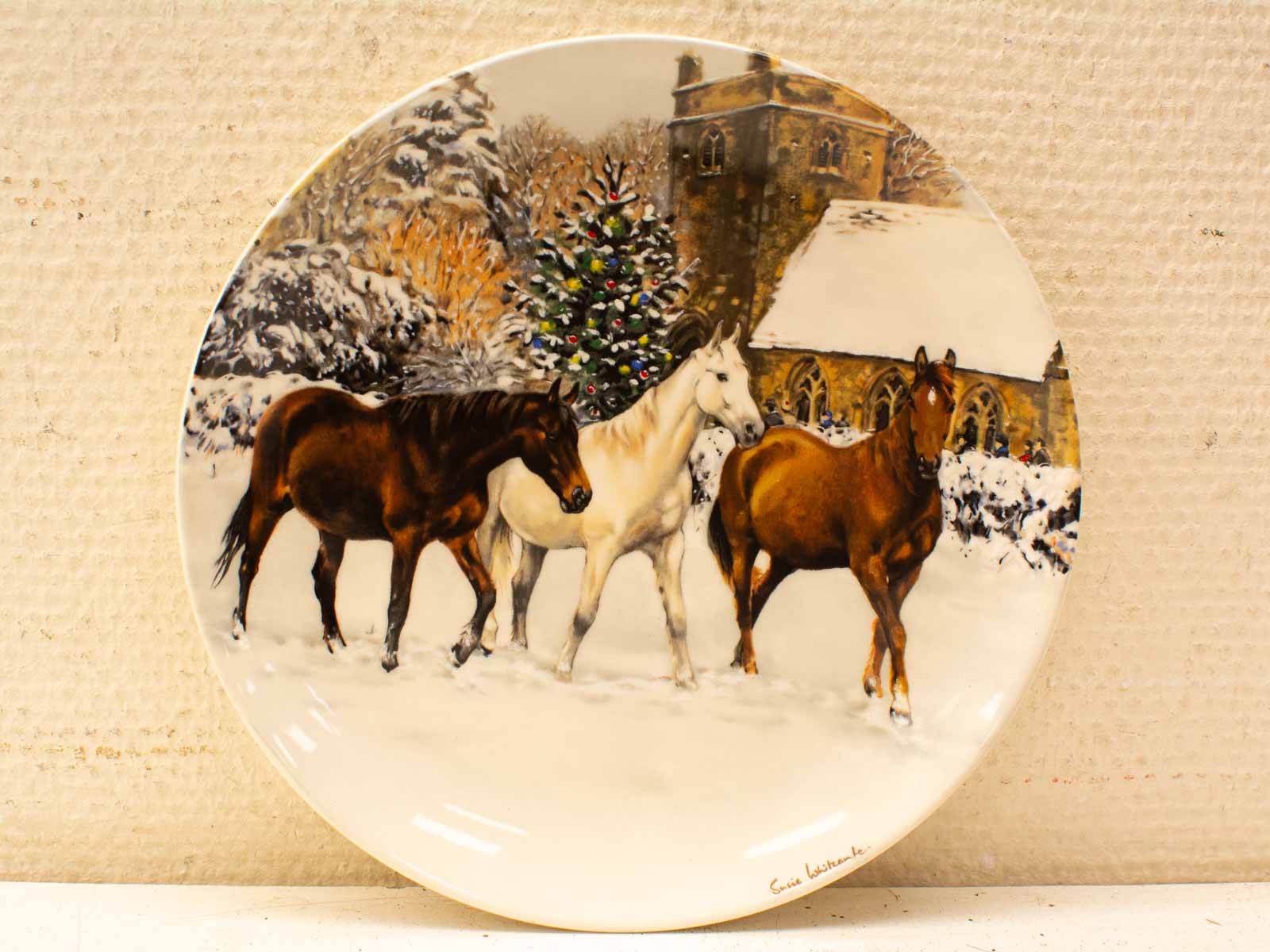 Elegant horses in a winter landscape, featuring festive decor and a charming church backdrop.