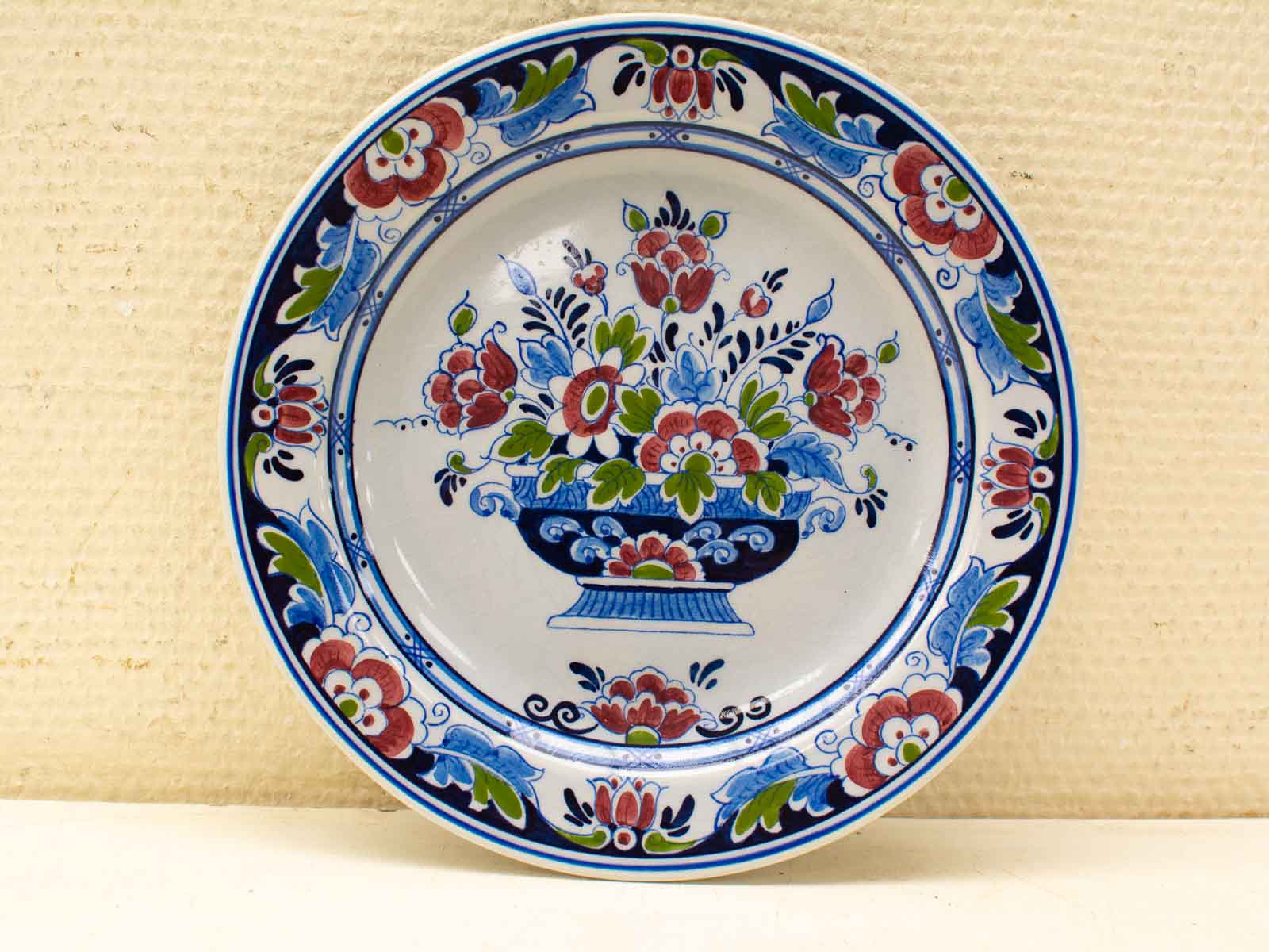 Vintage decorative plate with vibrant floral bouquet, showcasing exceptional craftsmanship and timeless beauty.