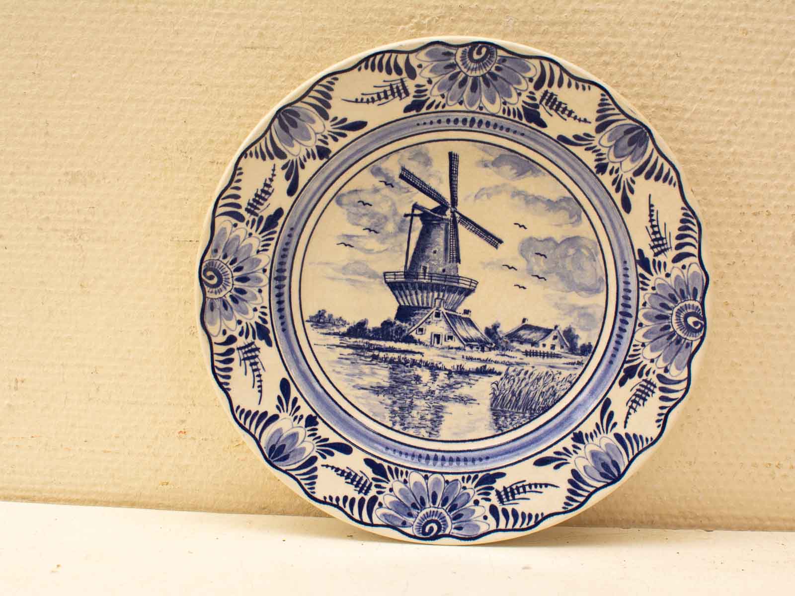 Elegant Delft Blue windmill plate showcasing classic Dutch scenery and intricate floral designs.