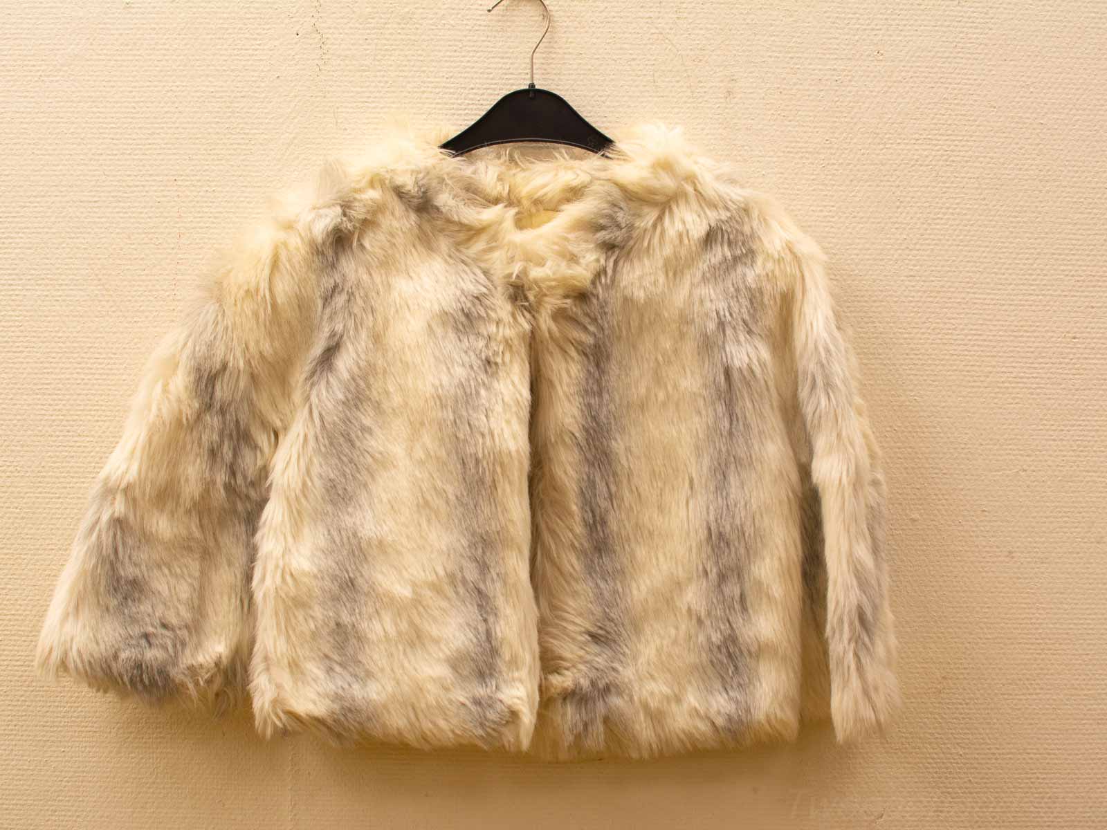 Stylish cropped creamy beige faux fur jacket with wide sleeves, perfect for versatile layering.