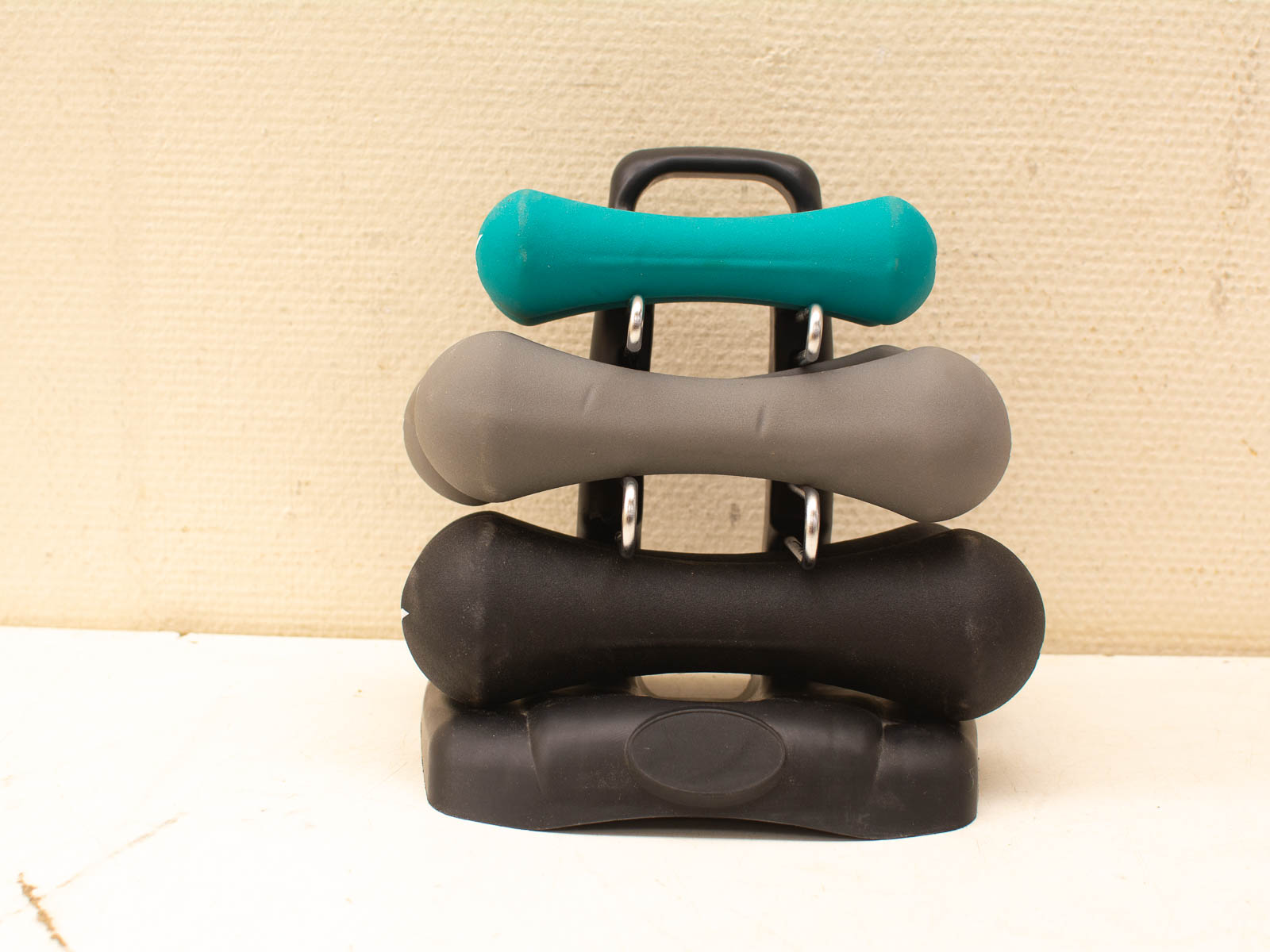 Vibrant dumbbells in turquoise, gray, and black, ideal for home strength training display.