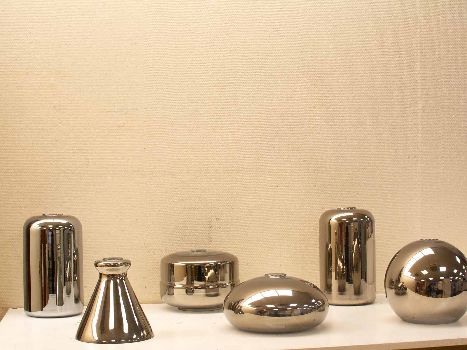 Modern metallic decor pieces on a white shelf, enhancing contemporary interior aesthetics.