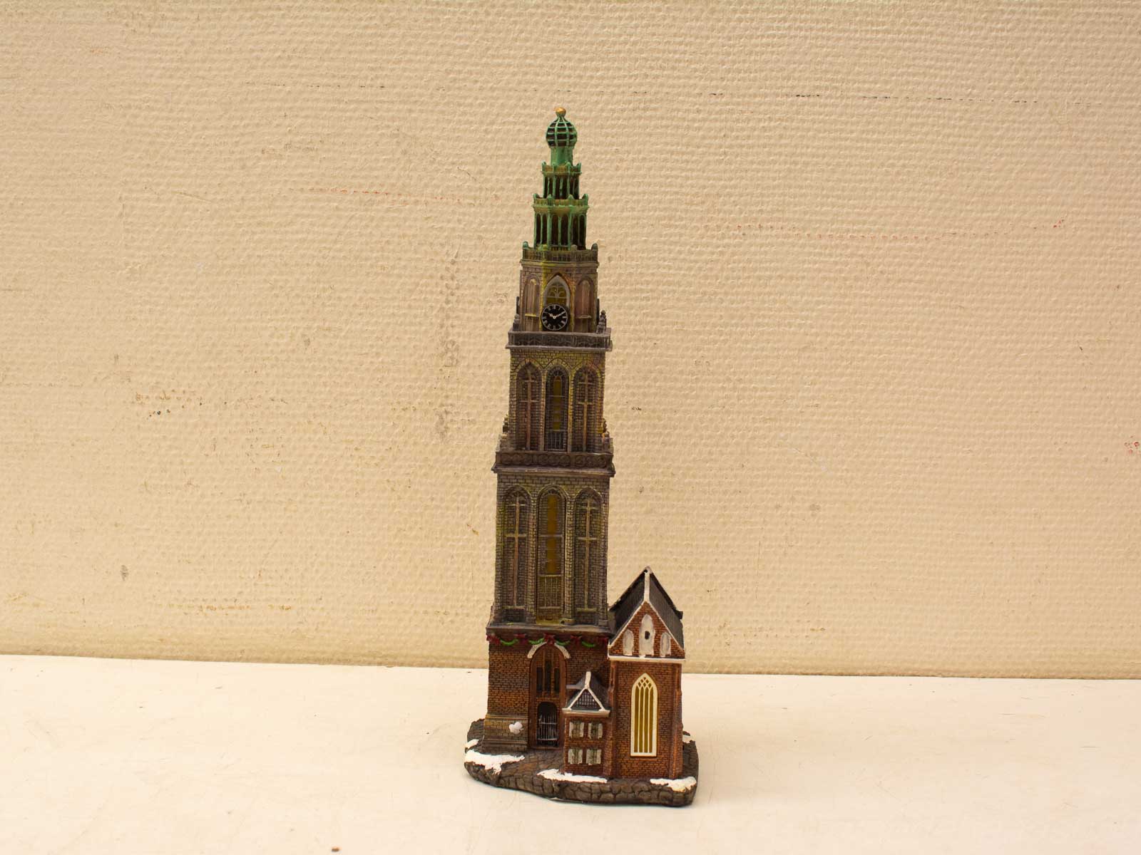 Stunning miniature tower model with clock and green dome, showcasing exquisite architectural craftsmanship.