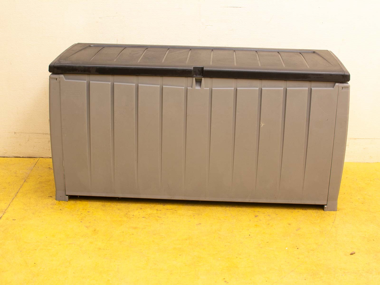 Durable gray storage box with black lid, perfect for outdoor tools and accessories.