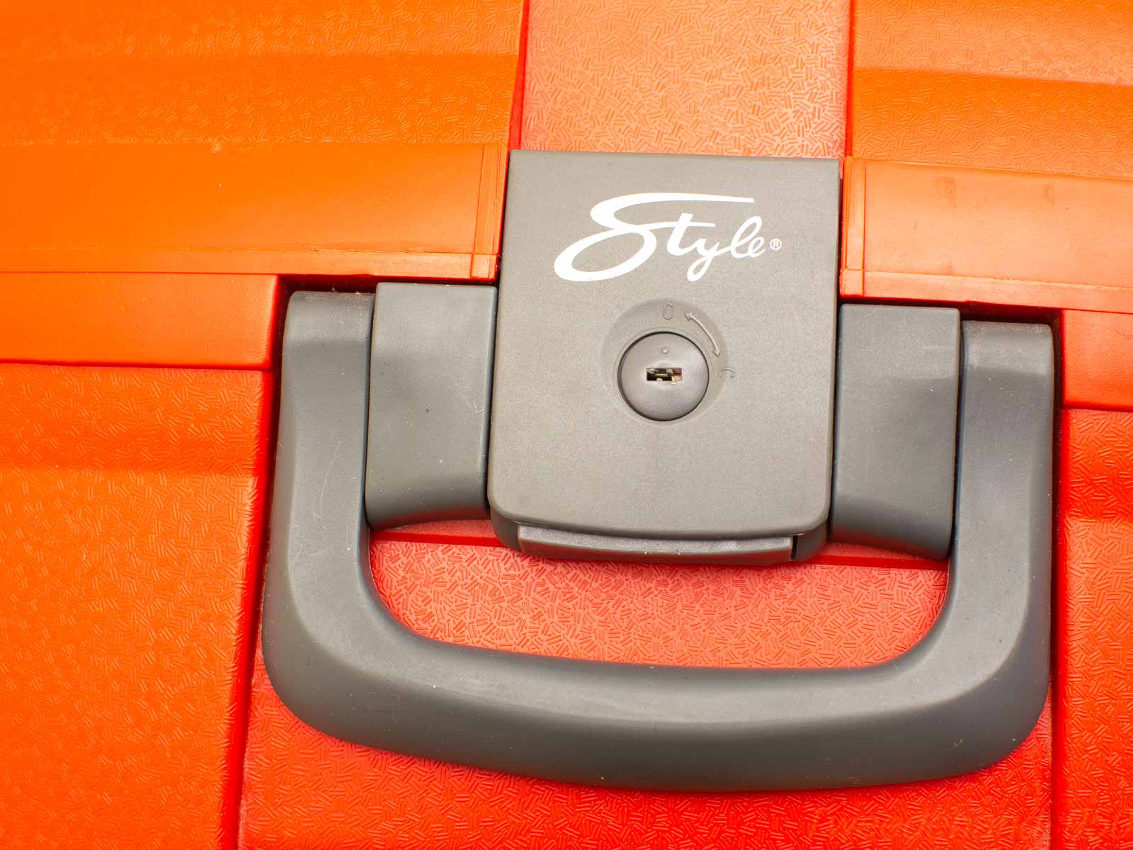 Vibrant orange suitcase with ergonomic handle and secure lock for stylish, modern travel.