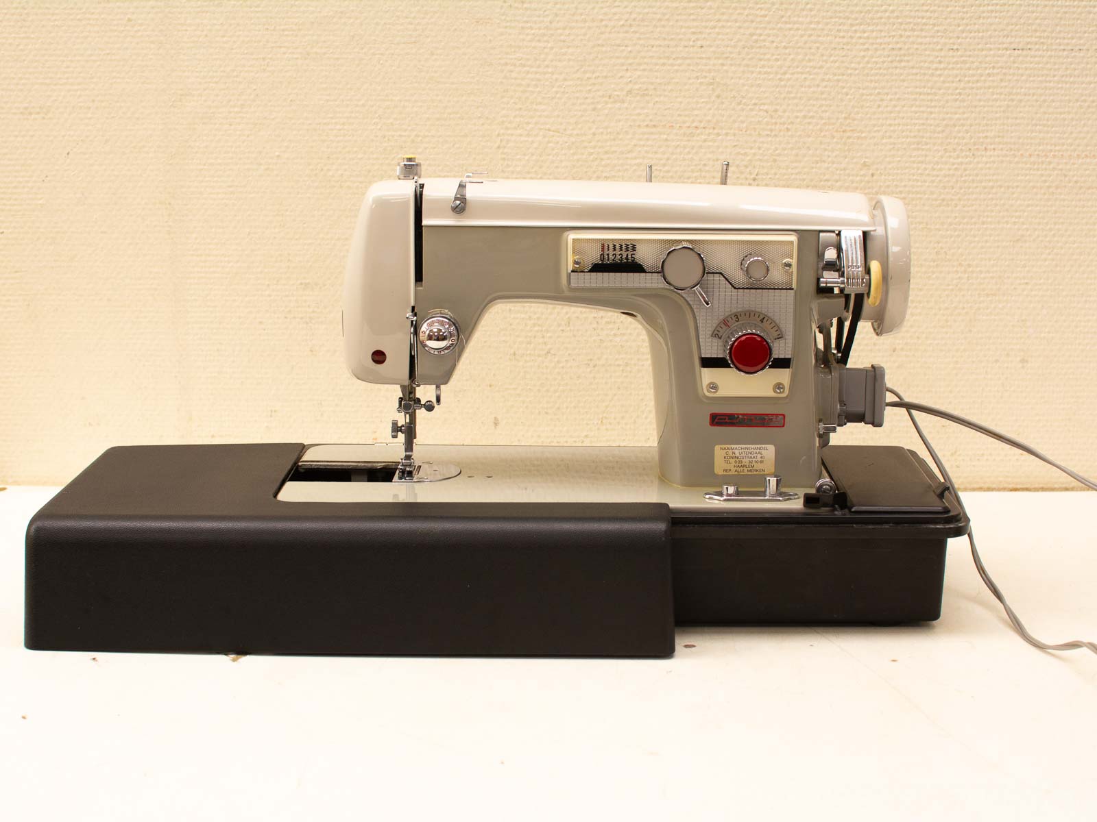 Charming vintage cream and black sewing machine with user-friendly controls and nostalgic appeal.