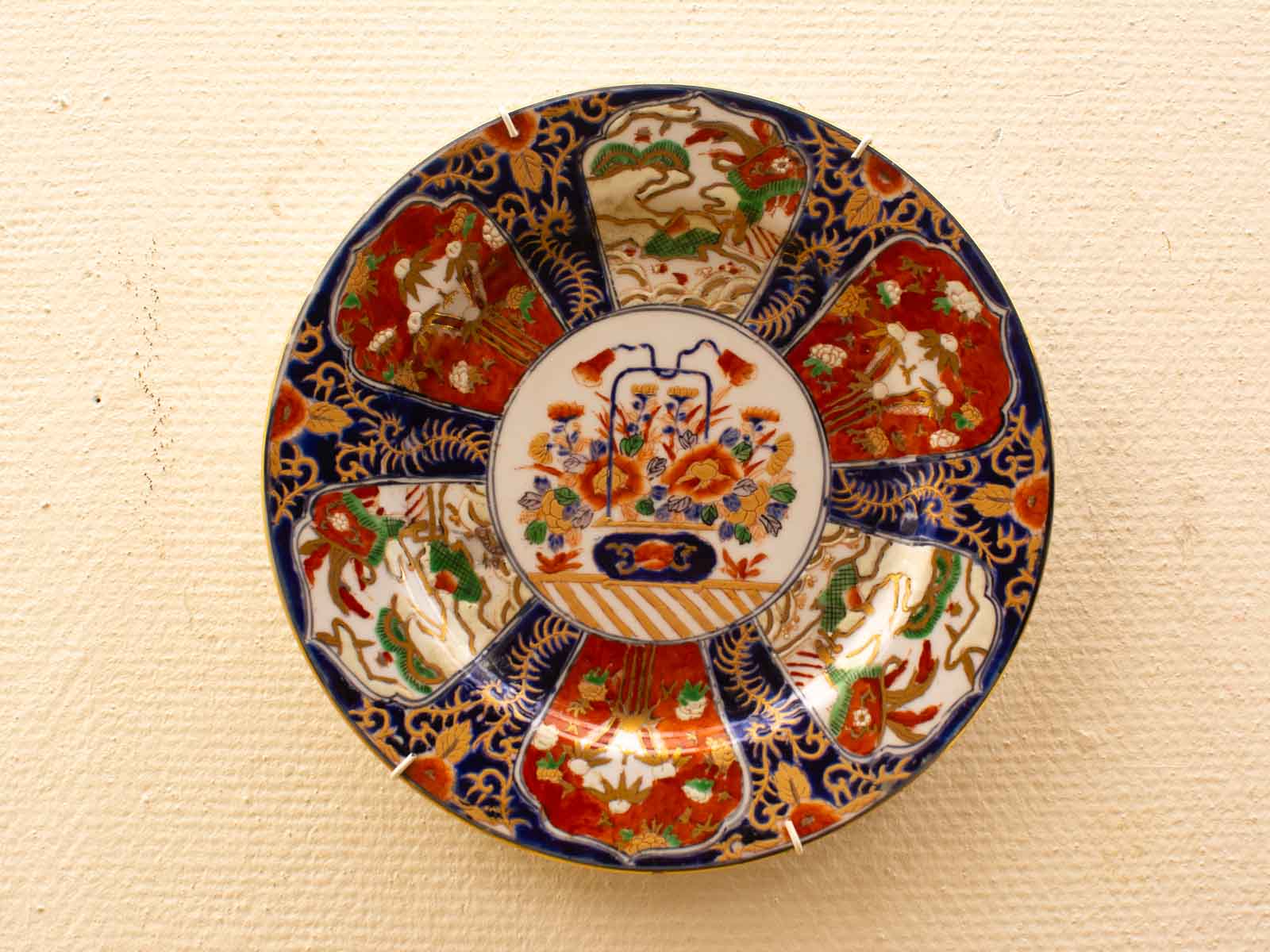 Vibrant decorative plate with floral designs and gold accents, perfect for home decor.