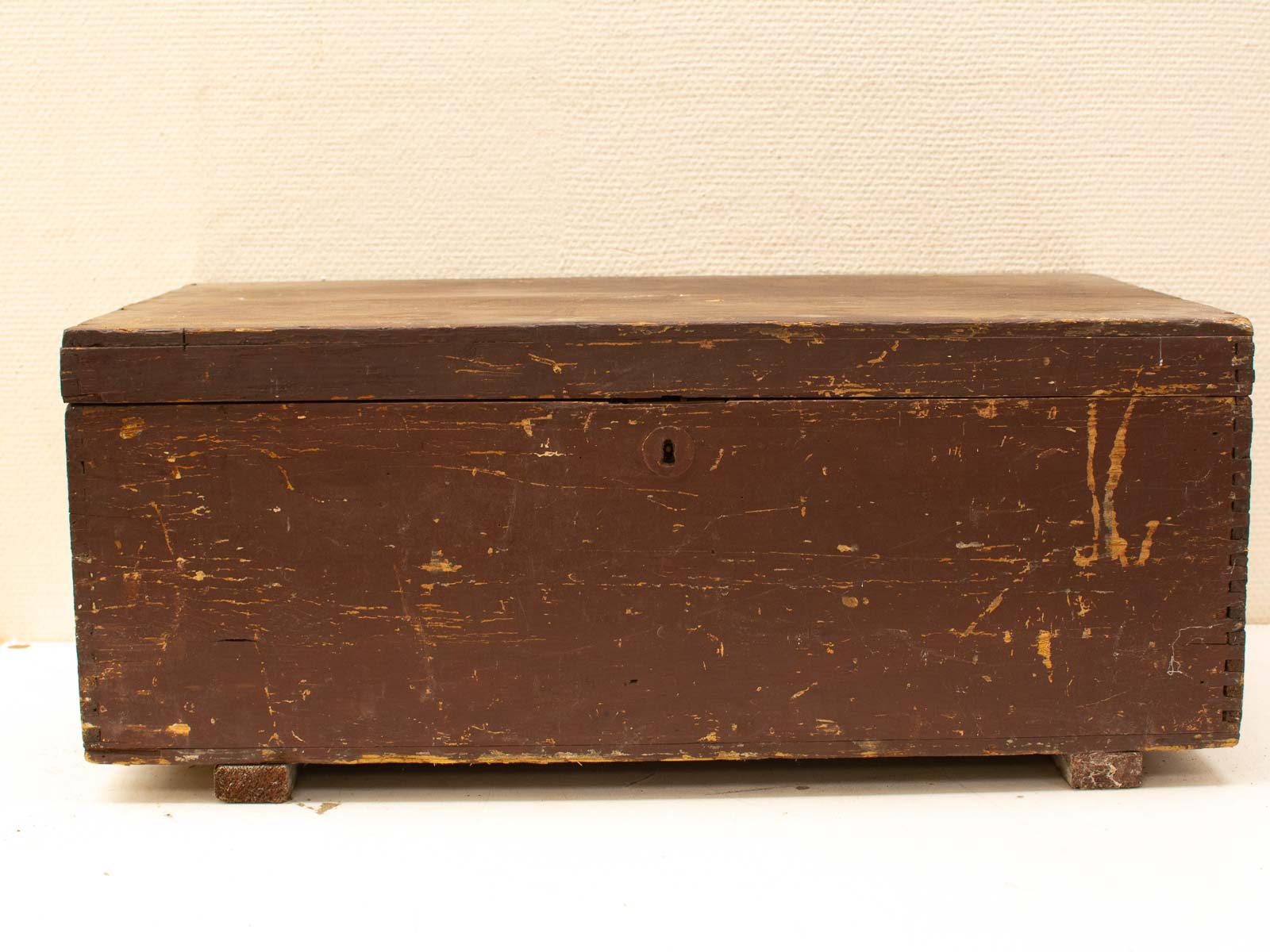 Rustic wooden box with keyhole, aged finish, and charming dovetail joints, perfect vintage decor.