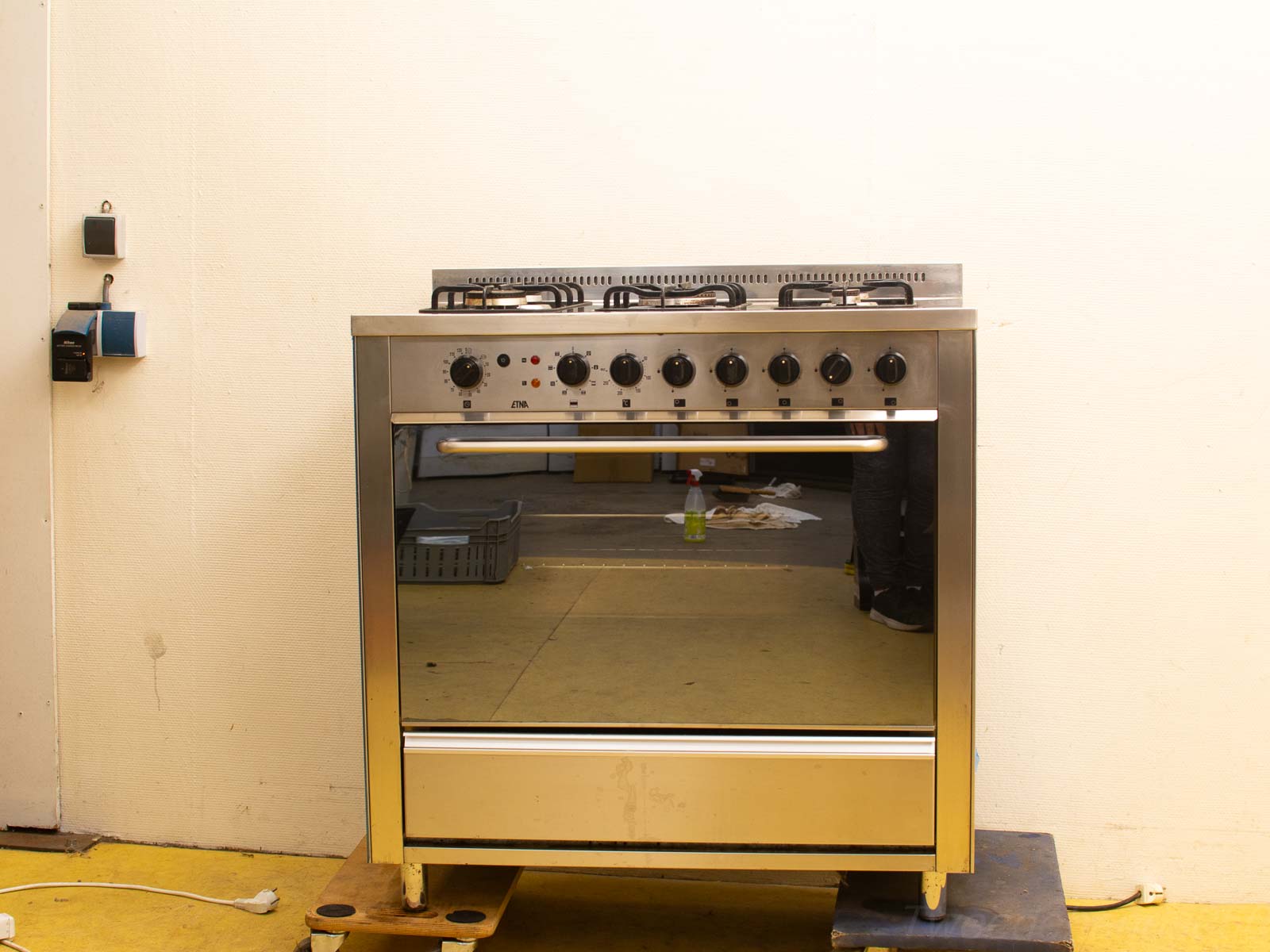 Sleek stainless steel gas stove with oven, four burners, and modern minimalist design.