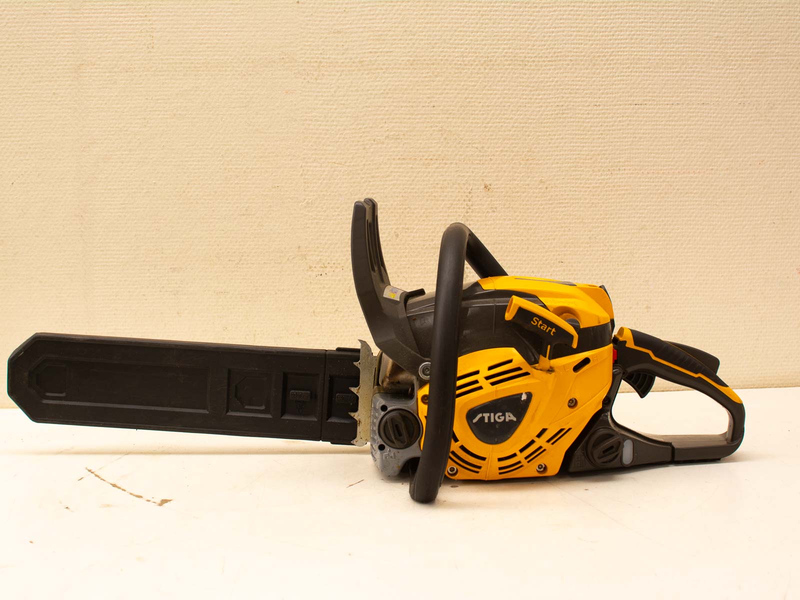 STIGA ergonomic chainsaw in yellow and black, designed for comfort and efficient cutting tasks.