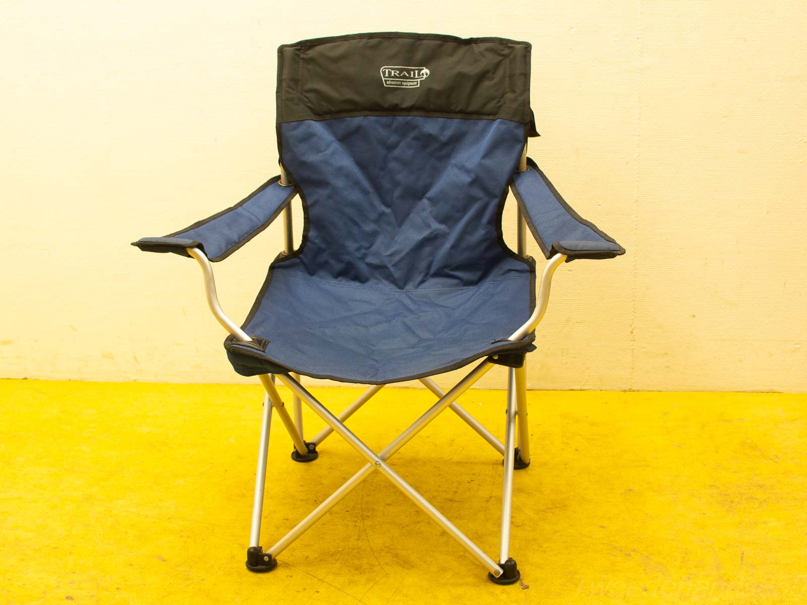 Lightweight navy blue folding chair with padded armrests, perfect for camping and beach outings.