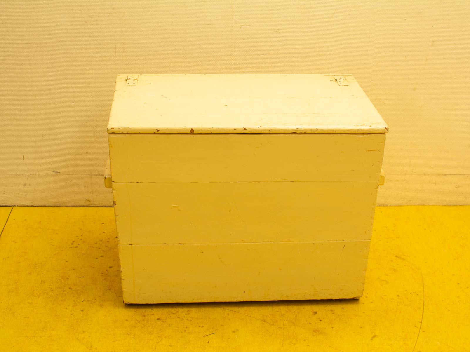 Charming weathered yellow wooden storage box, perfect for rustic decor and organization.