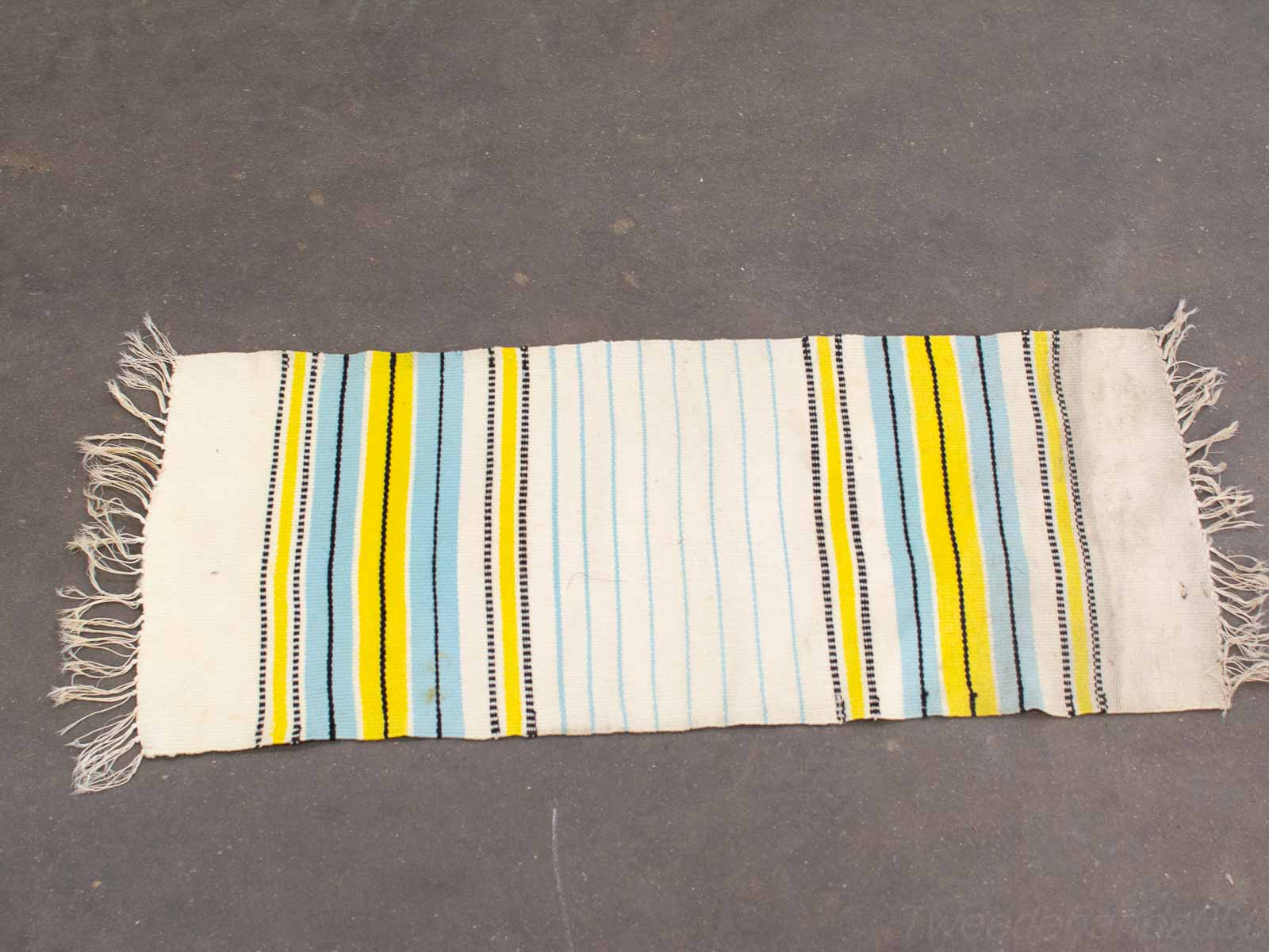 Colorful striped woven rug in blue, yellow, and black adds modern charm to any space.