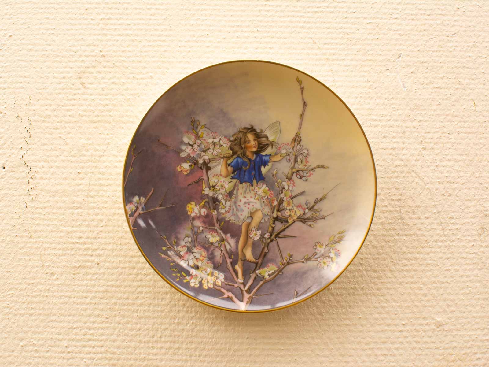 Whimsical fairy on flowers decorative plate, vibrant colors, enchanting garden charm for collectors.