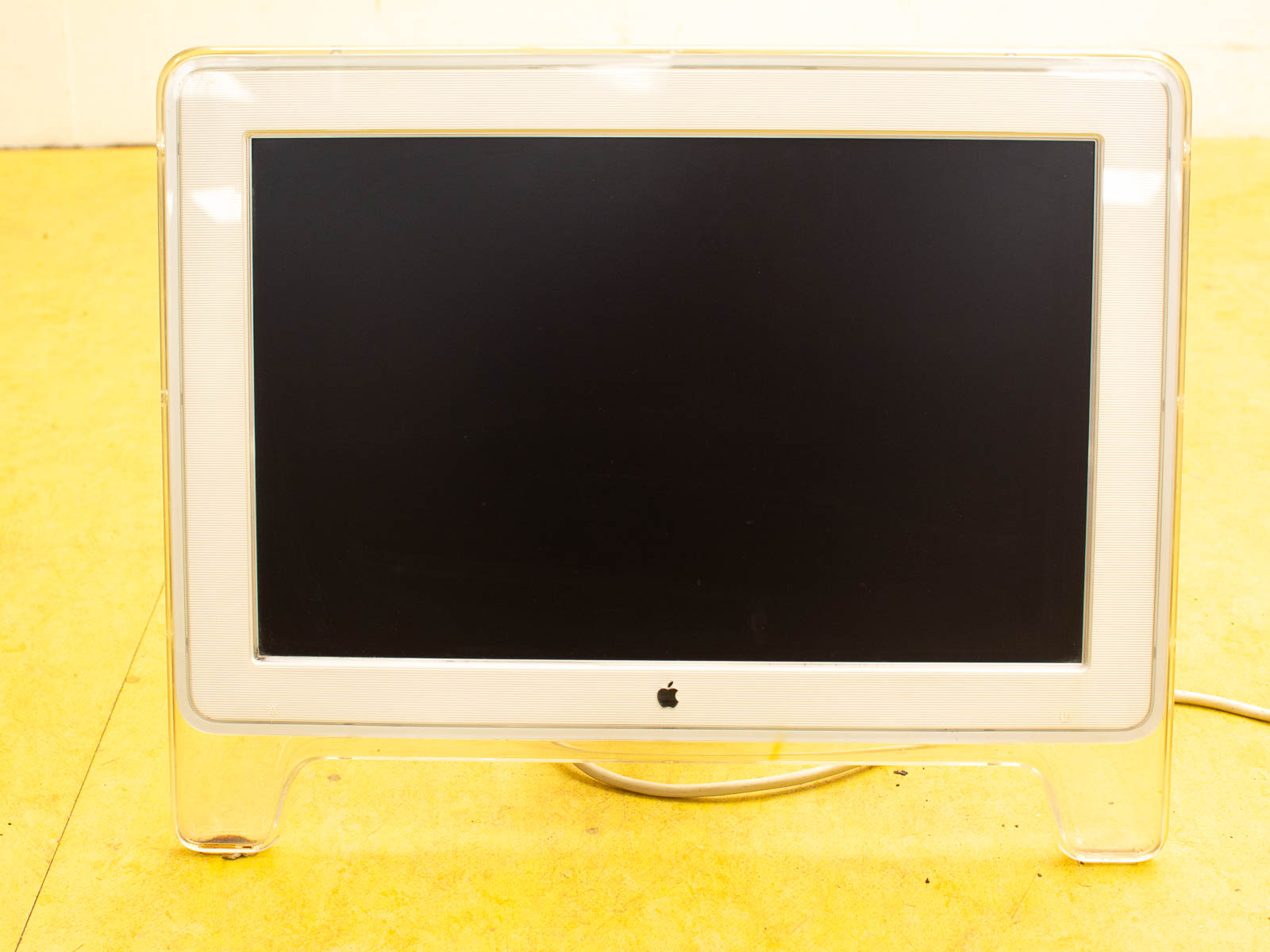 Sleek vintage Apple monitor with transparent design, rounded legs, perfect for creative workspaces.