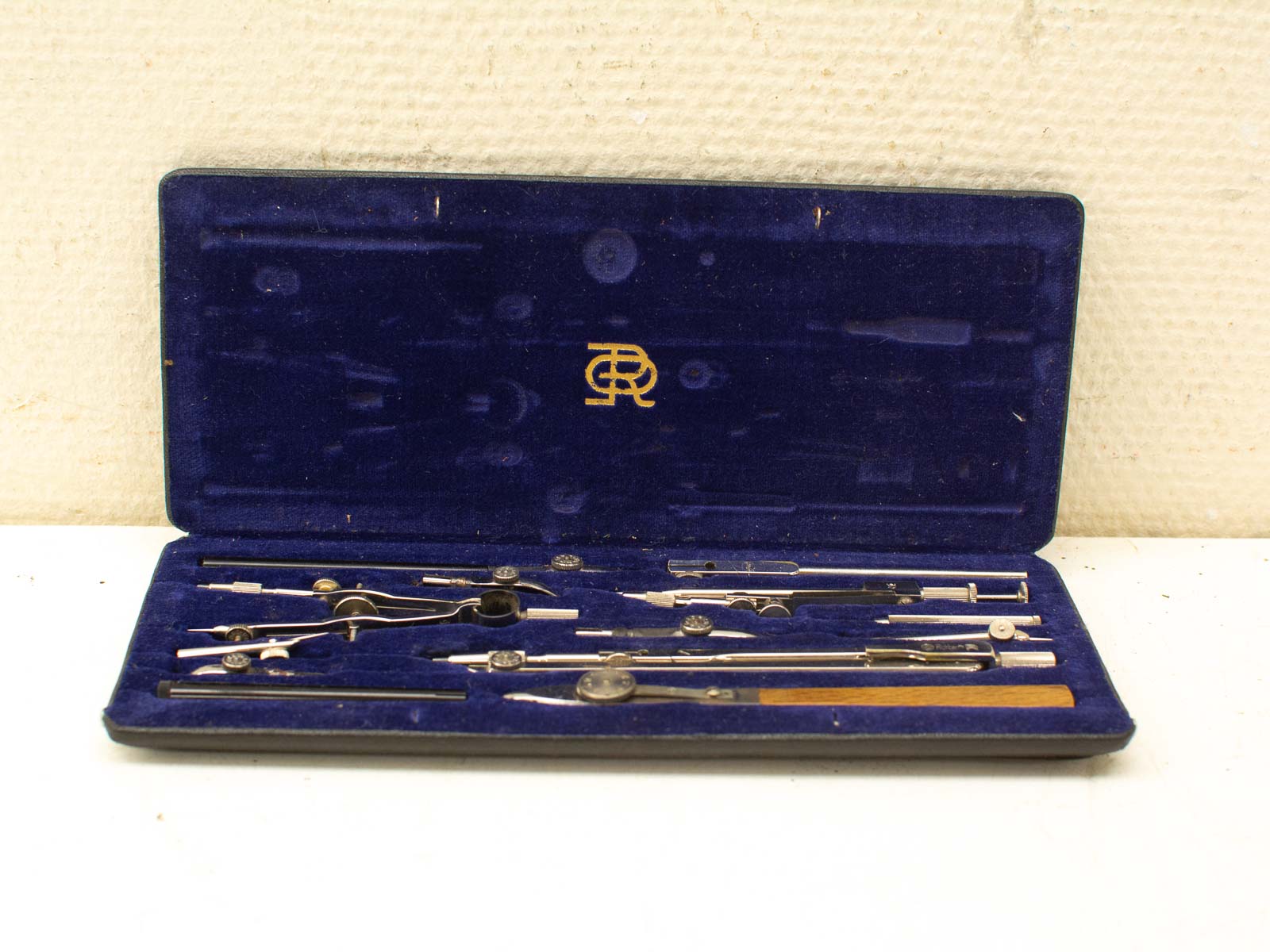 Elegant vintage compass set in luxurious blue velvet case, perfect for architects and designers.