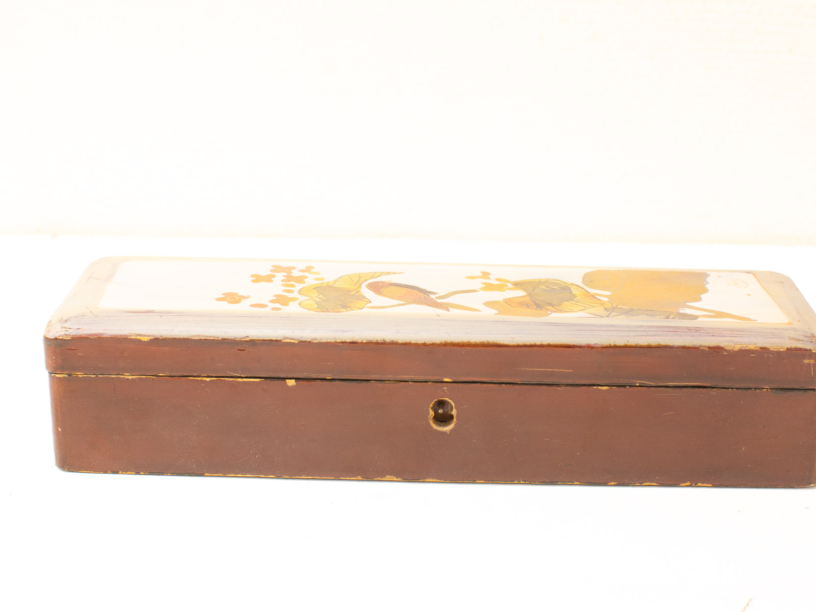 Vintage wooden box with ornate bird and branch design, perfect for storage or display.