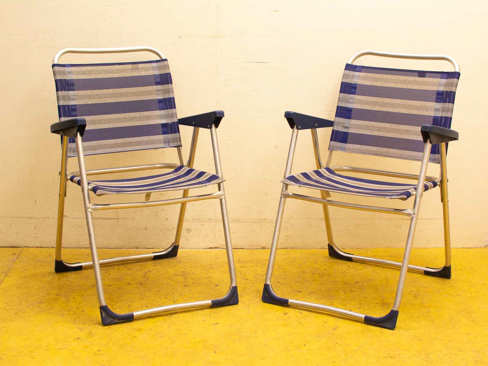 Modern folding chairs in blue and gray on a bright yellow floor, ideal for casual settings.