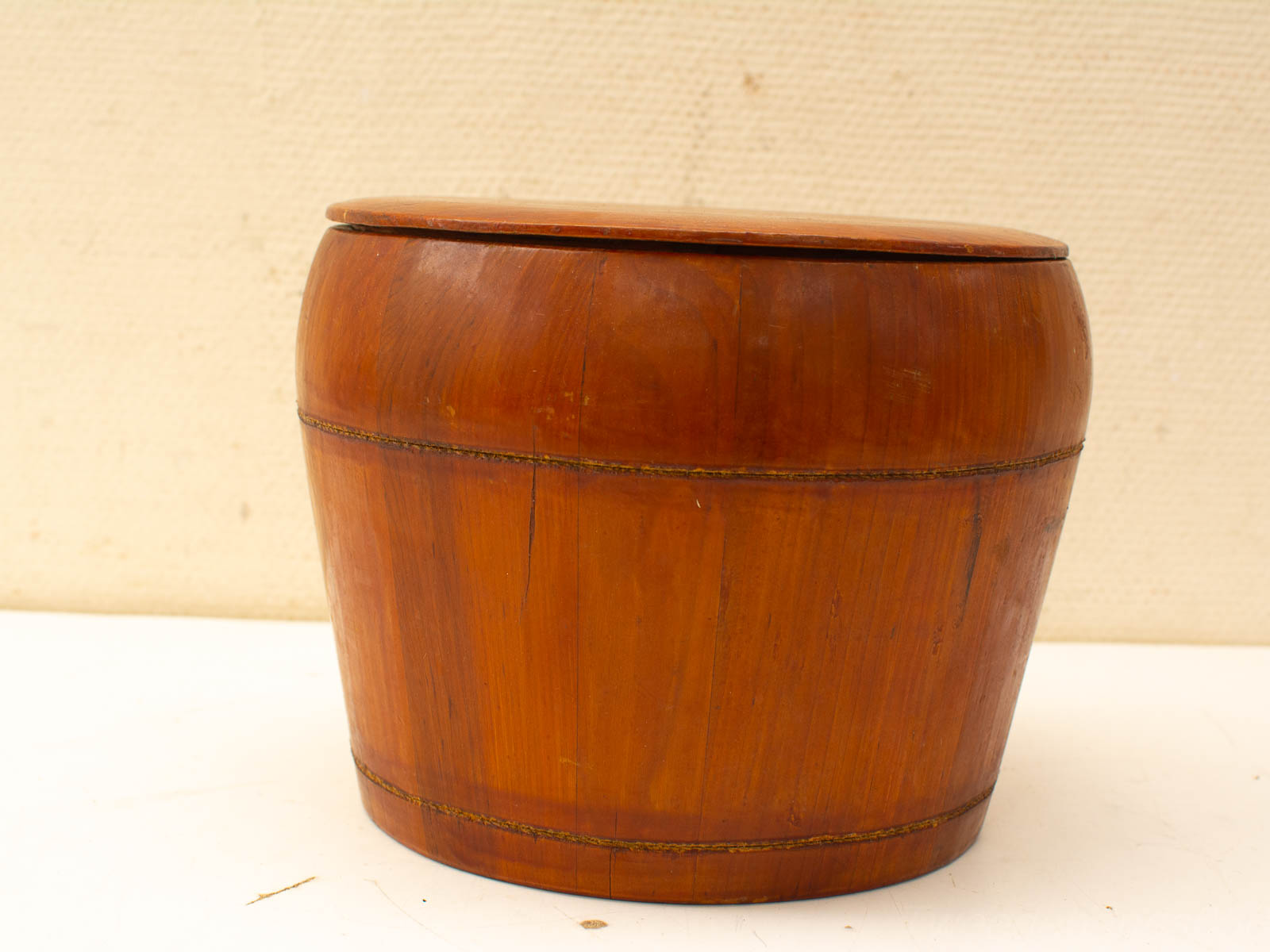 Elegant handcrafted wooden storage barrel with lid, featuring rich amber finish and contrasting dark bands.