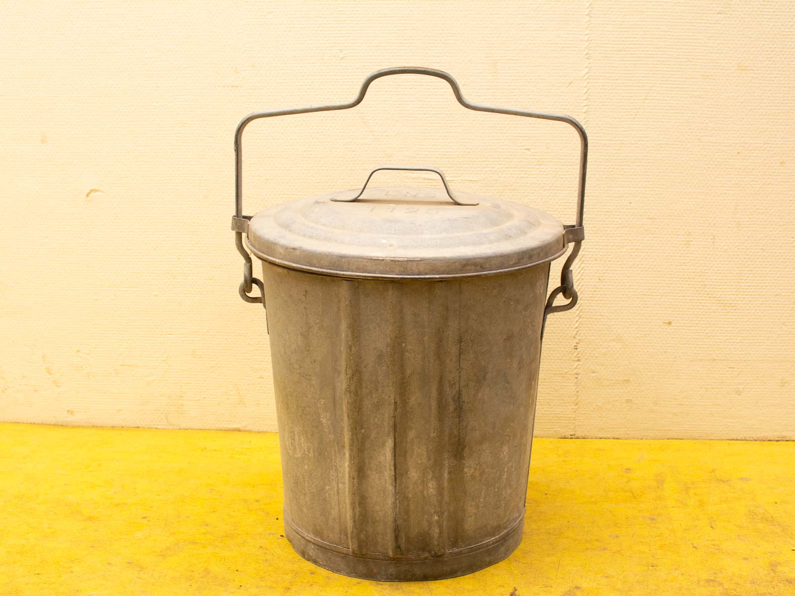 Vintage galvanized steel bucket with lid and handle, perfect for storage and decoration.