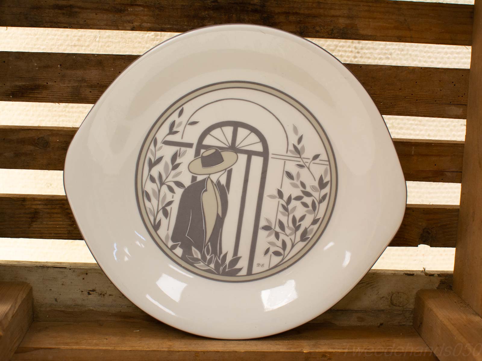 Elegant vintage plate featuring a mysterious figure and doorway illustration on a rustic backdrop.