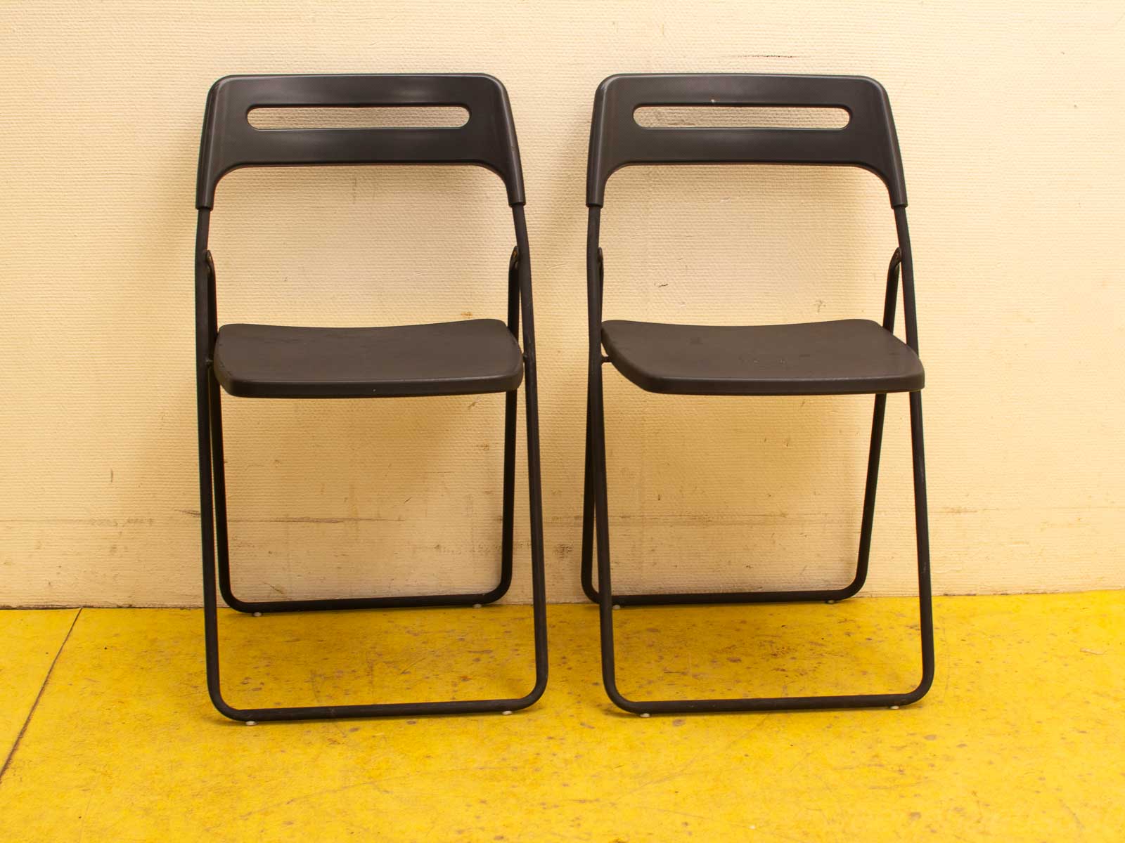 Sleek black folding chairs, ideal for versatile seating at home or events.