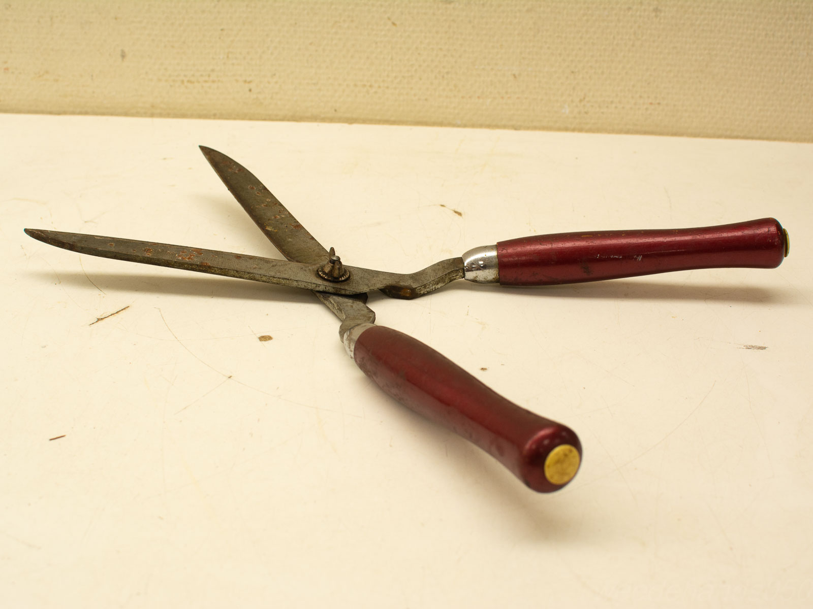 Vintage scissors with burgundy handles, showing wear, rust, and a nostalgic charm.