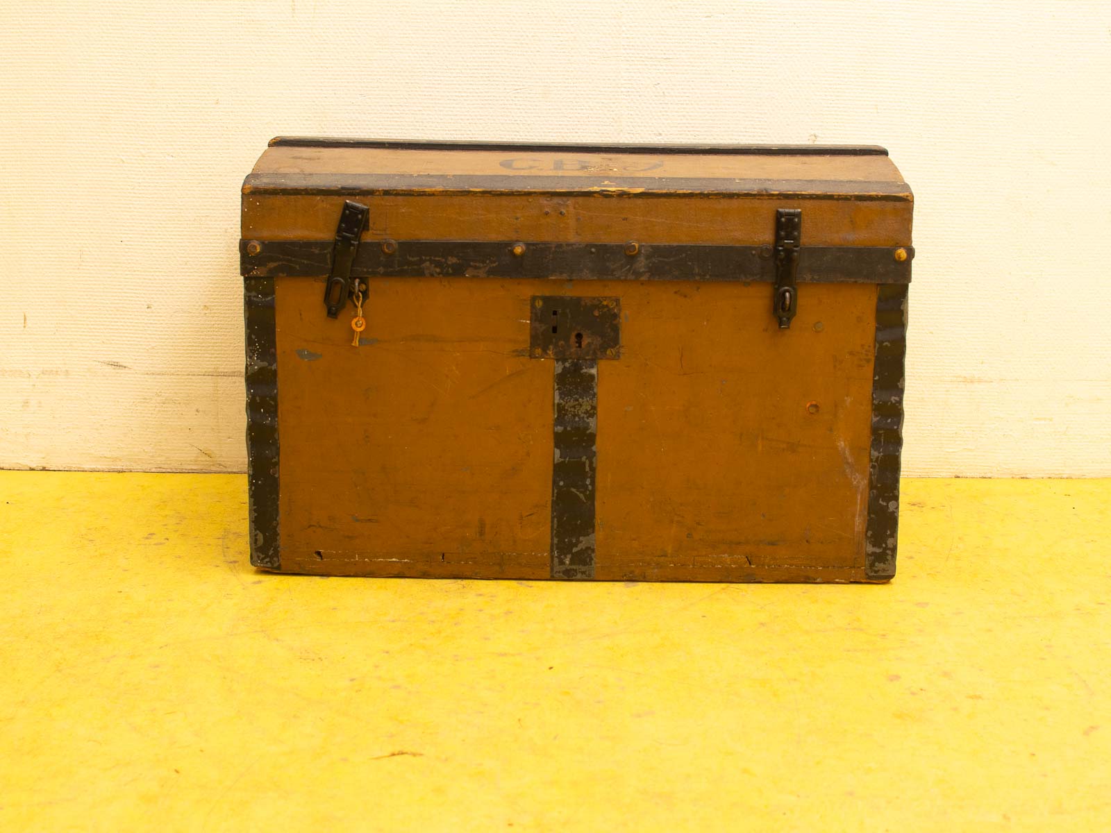 Vintage mustard yellow trunk with metal accents, perfect for storage and decor.