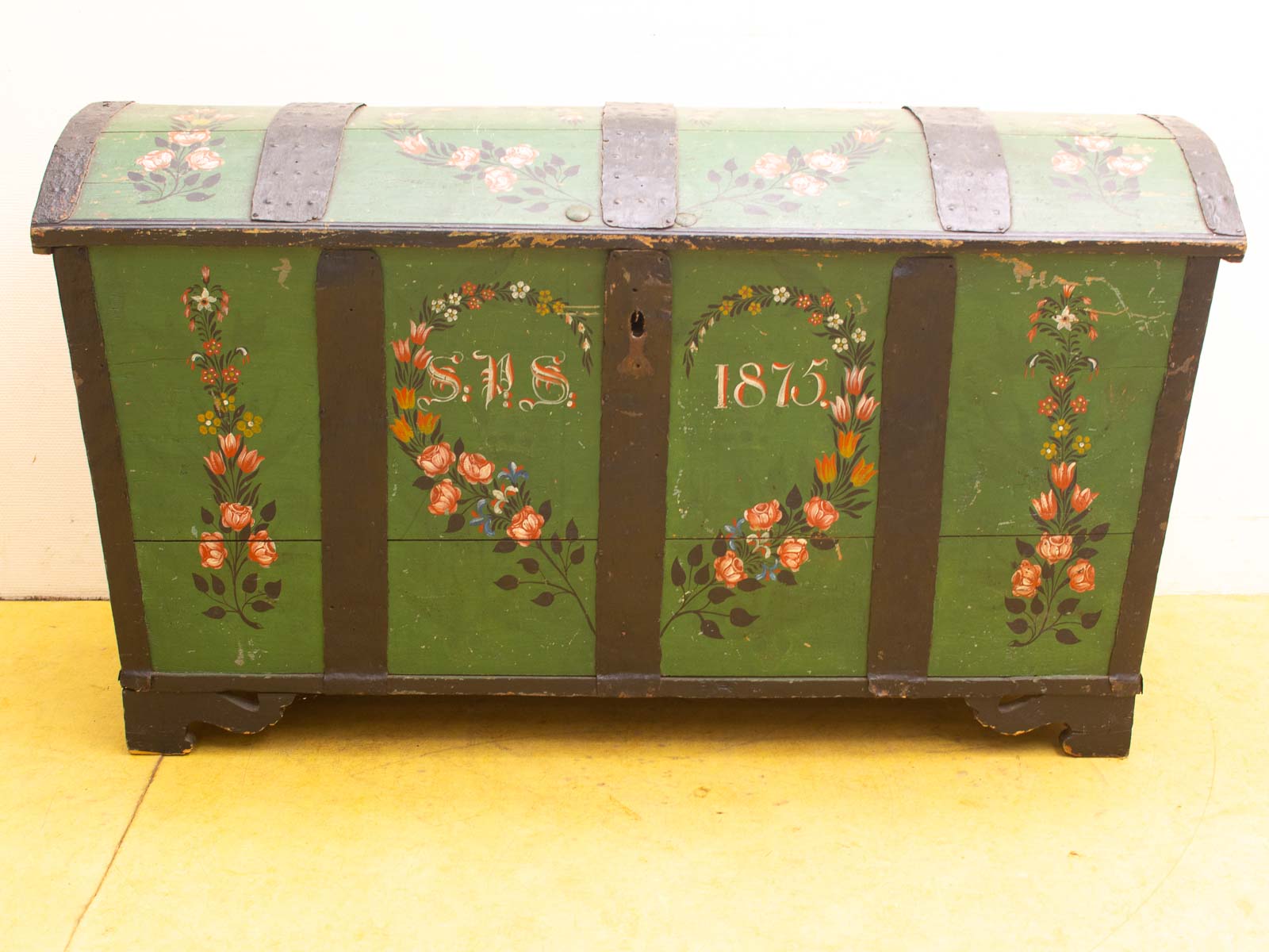 Vintage groene kist uit 1875 met bloemenmotieven en metalen banden, perfect voor decoratie.