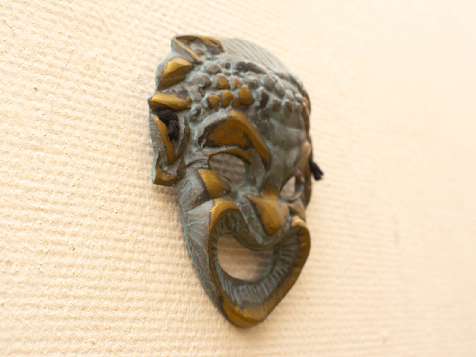 Intricate bronze mask with floral motifs, showcasing cultural artistry and dramatic expression.