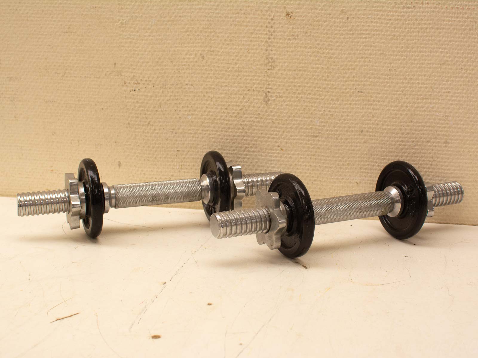 Tweedehands dumbbells met rubberen gewichten op een lichte ondergrond, klaar voor training.