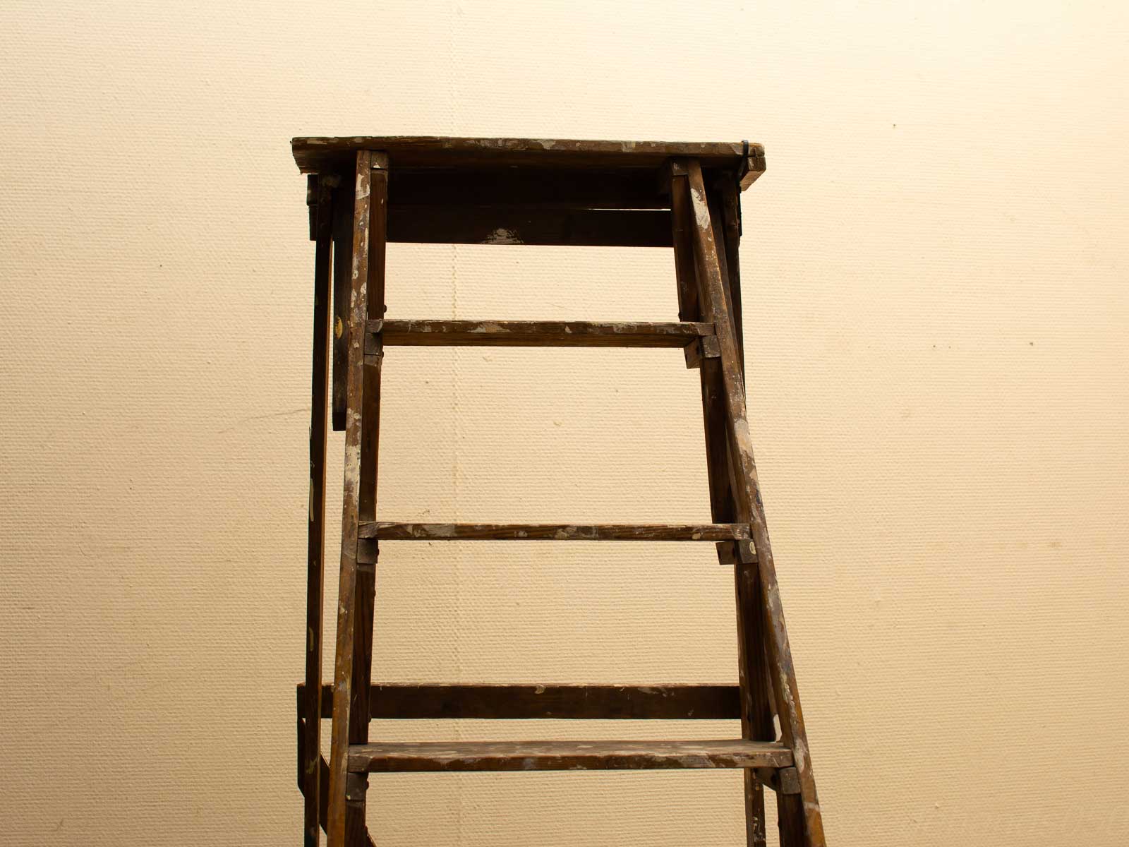 Houten ladder met een rustieke uitstraling tegen een neutrale achtergrond, perfect voor tweedehands decoratie.