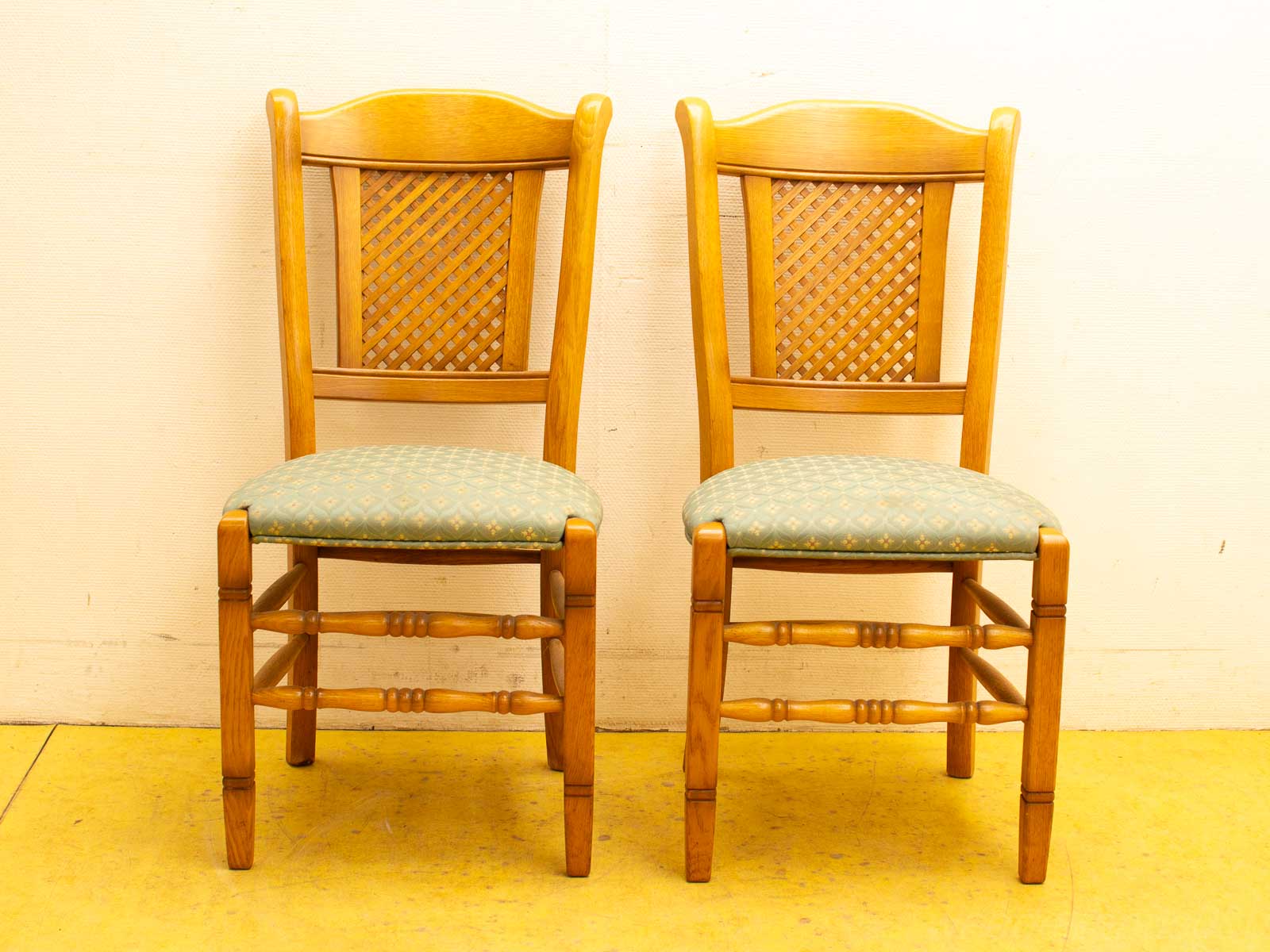 Elegant wooden chairs with green upholstery and intricate woven backrests, perfect for stylish interiors.