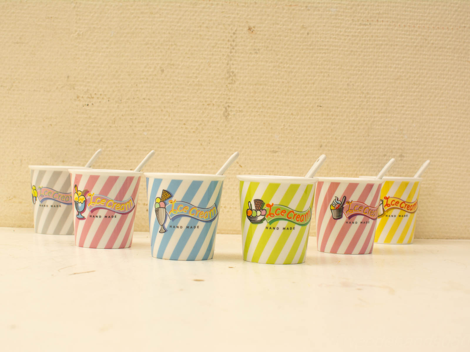 Colorful ice cream cups with spoons, perfect for enjoying sweet summer treats.