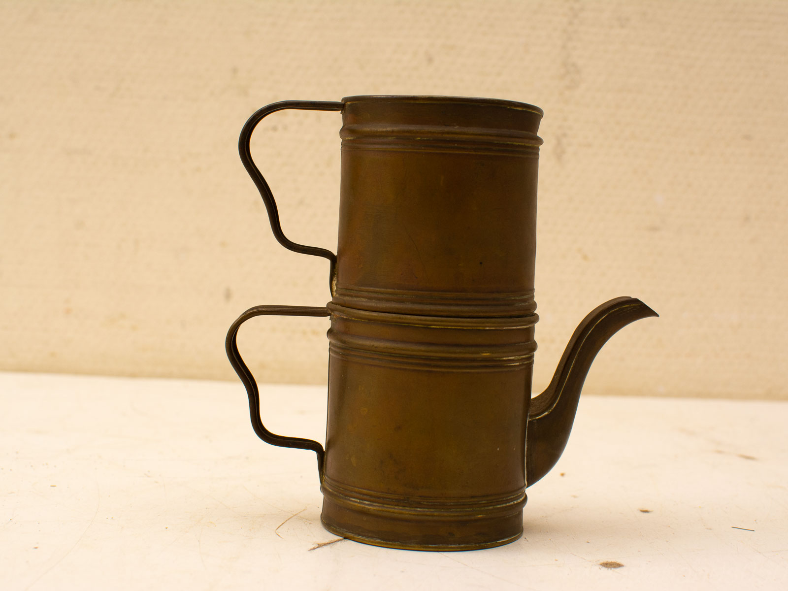 Antique brass tea kettle with elegant handles, showcasing vintage craftsmanship and timeless beauty.