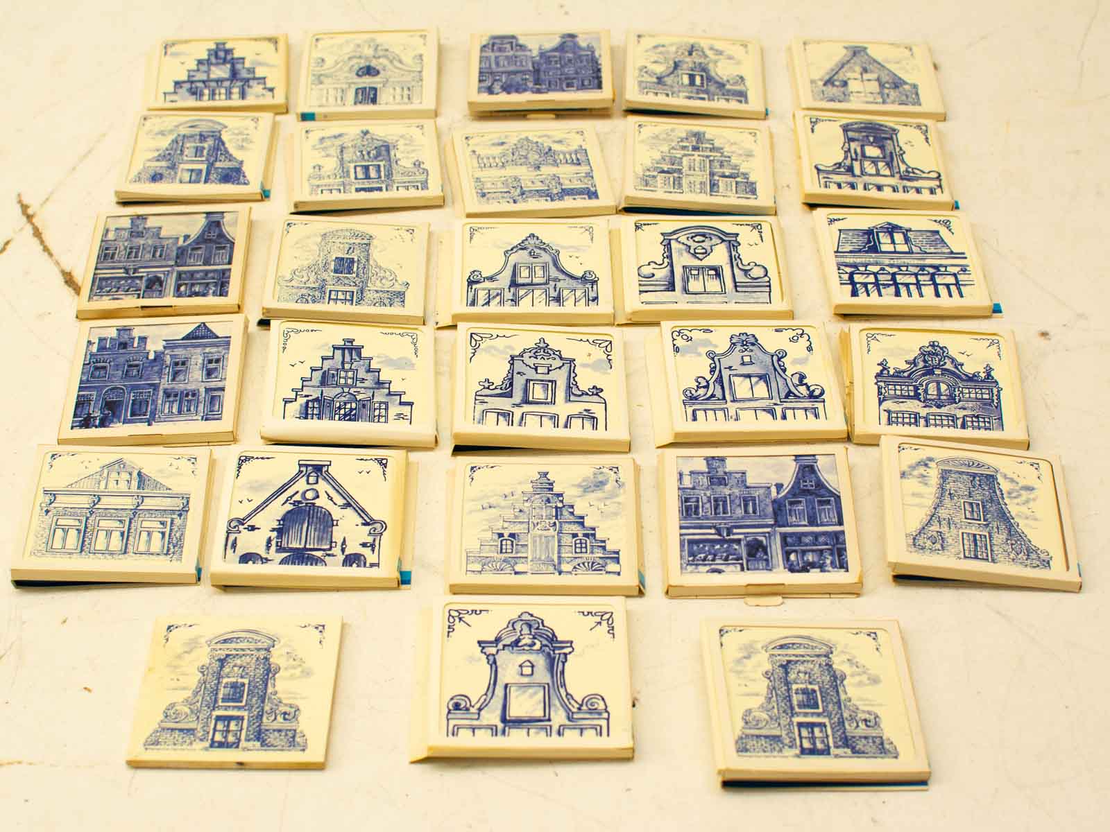 Charming vintage Delft blue tiles featuring intricate European architectural designs in a decorative collection.