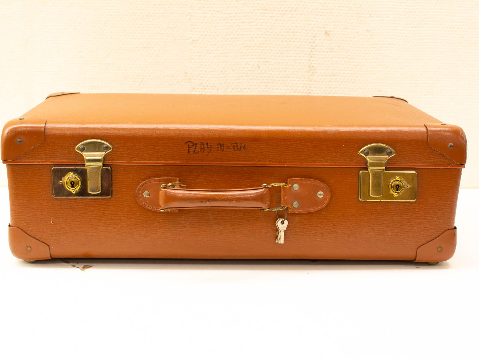 Vintage suitcase with brass lock and PLAY mobile inscription for toy storage.