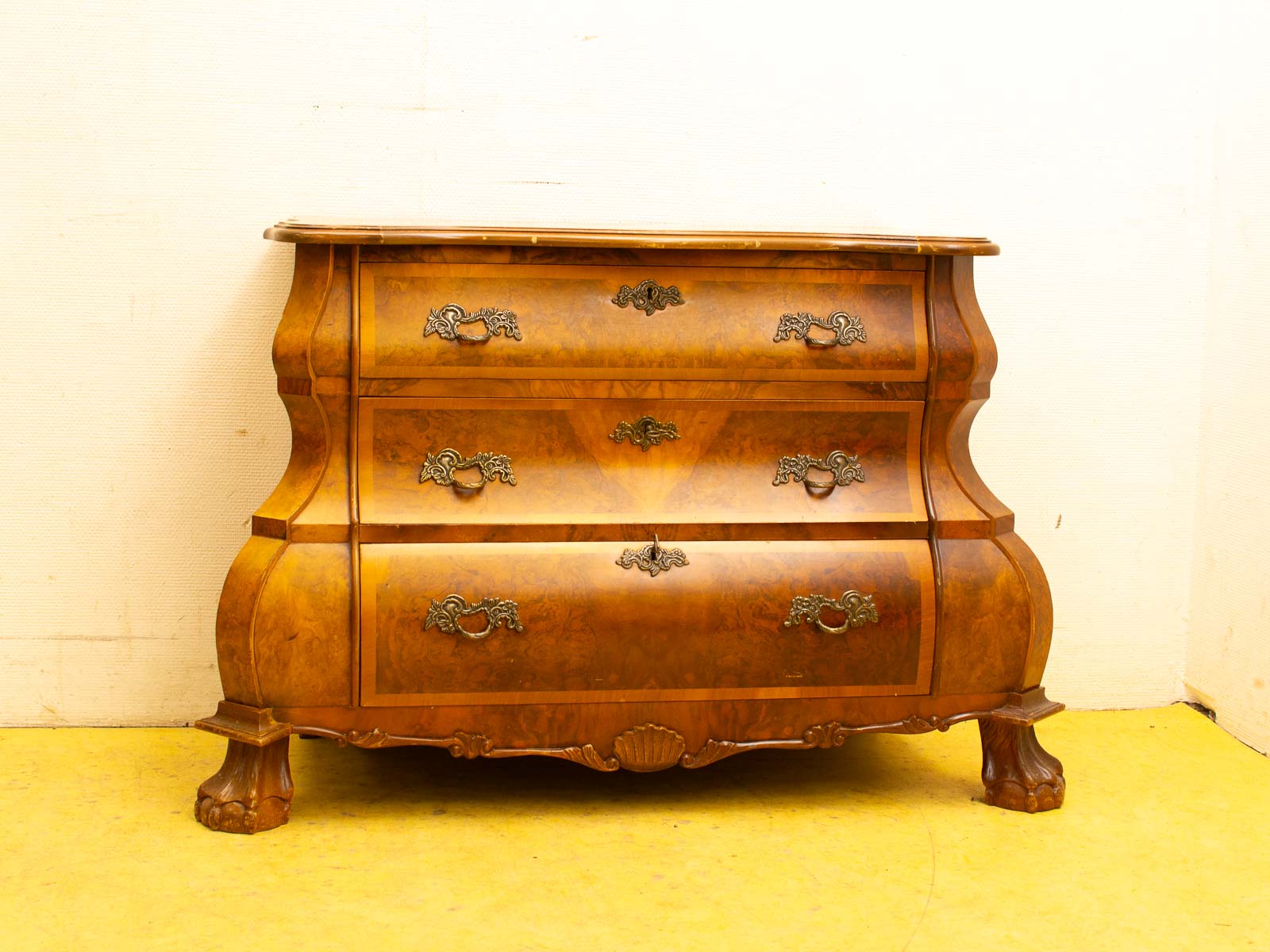 Elegant vintage chest of drawers in rich wood, featuring intricate handles and timeless design.