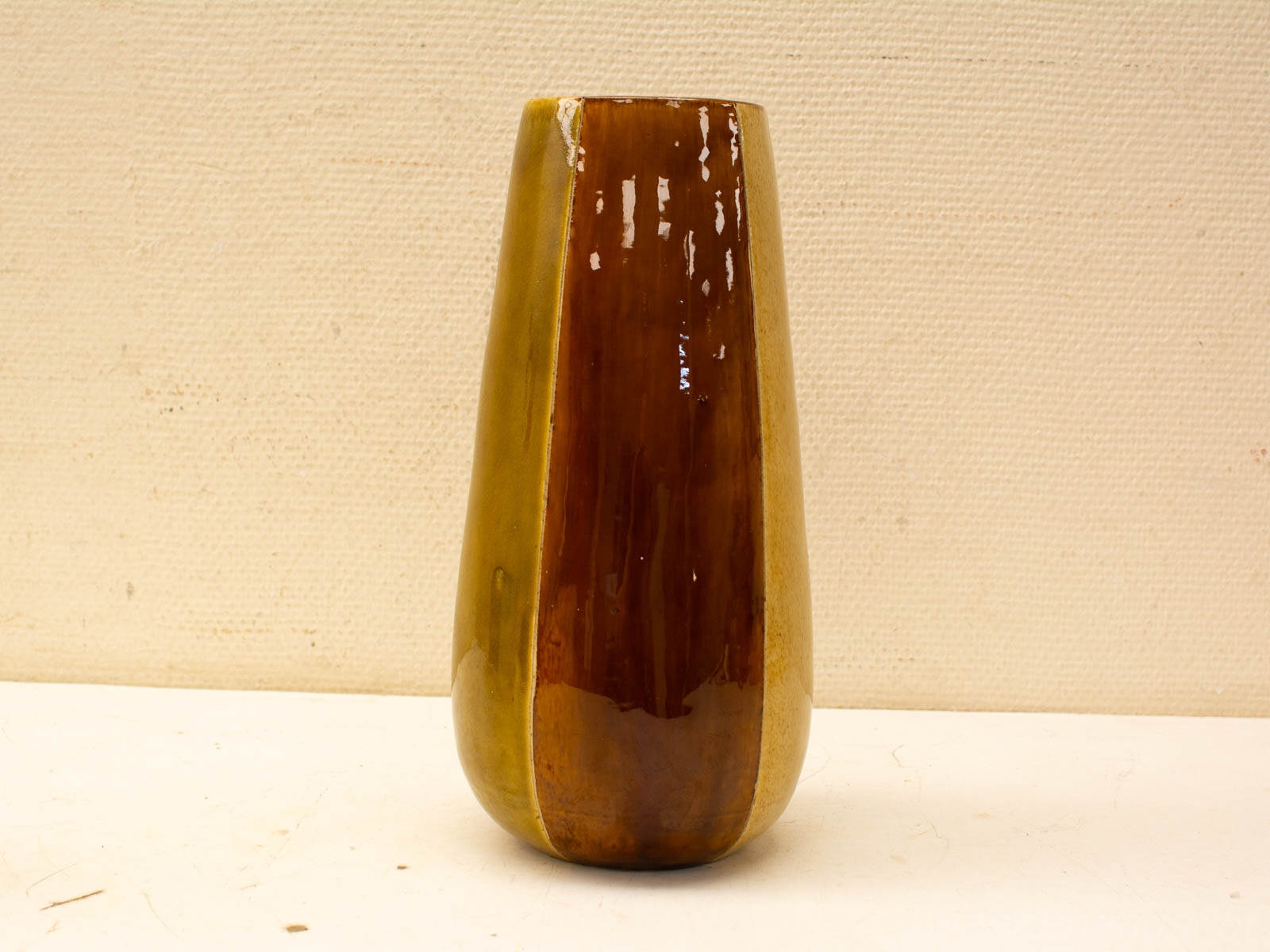 Elegant two-tone ceramic vase in chocolate brown and olive green, perfect for decor or flowers.